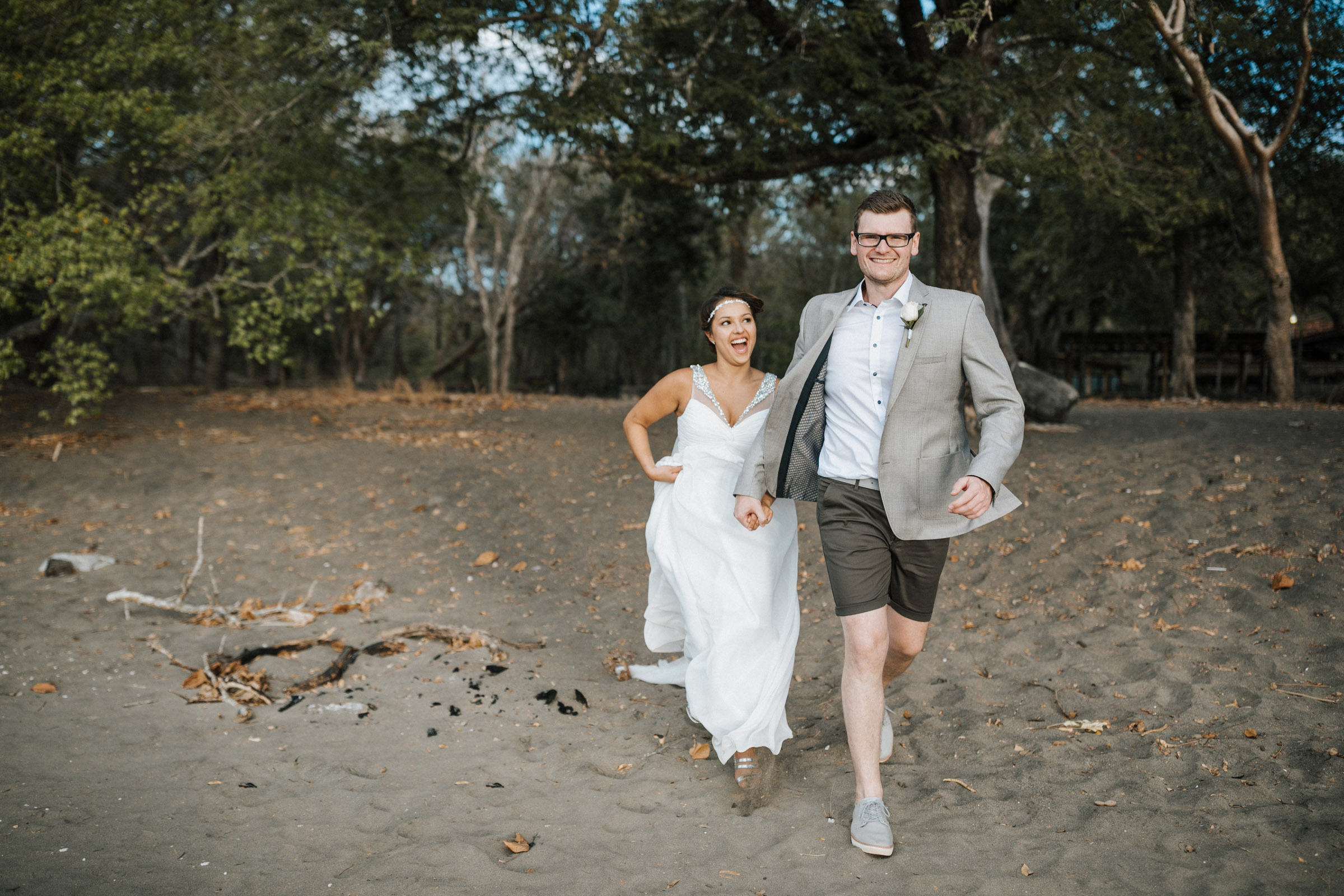 Heiraten in Costa Rica - rennendes Brautpaar, Bräutigam läuft vorne, Braut lachend hinterher
