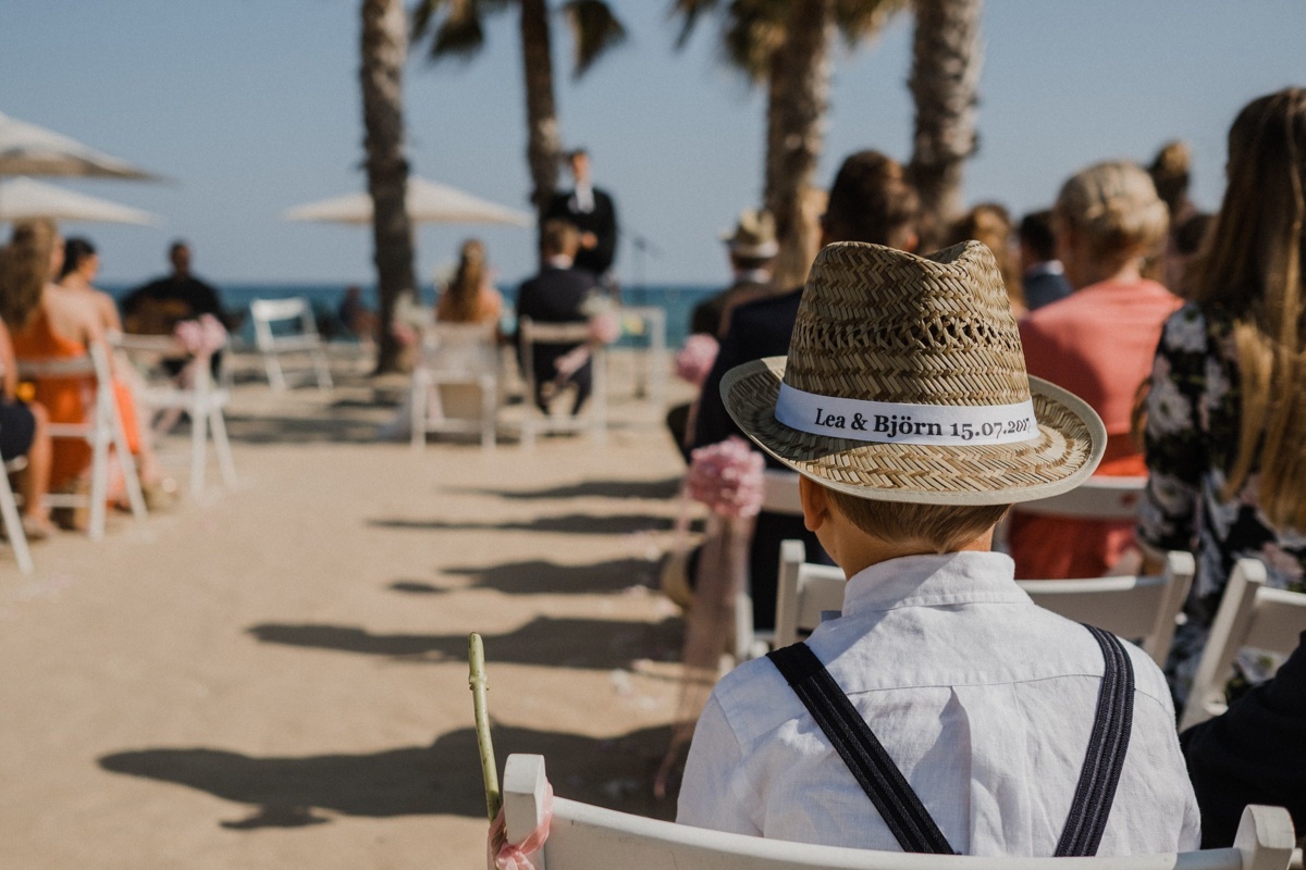 Frau Siemers - Bildpoeten - Heiraten in Barcelona - La Rambla Strandhochzeit, Kind von hinten fotografiert mit Blick auf das Brautpaar.