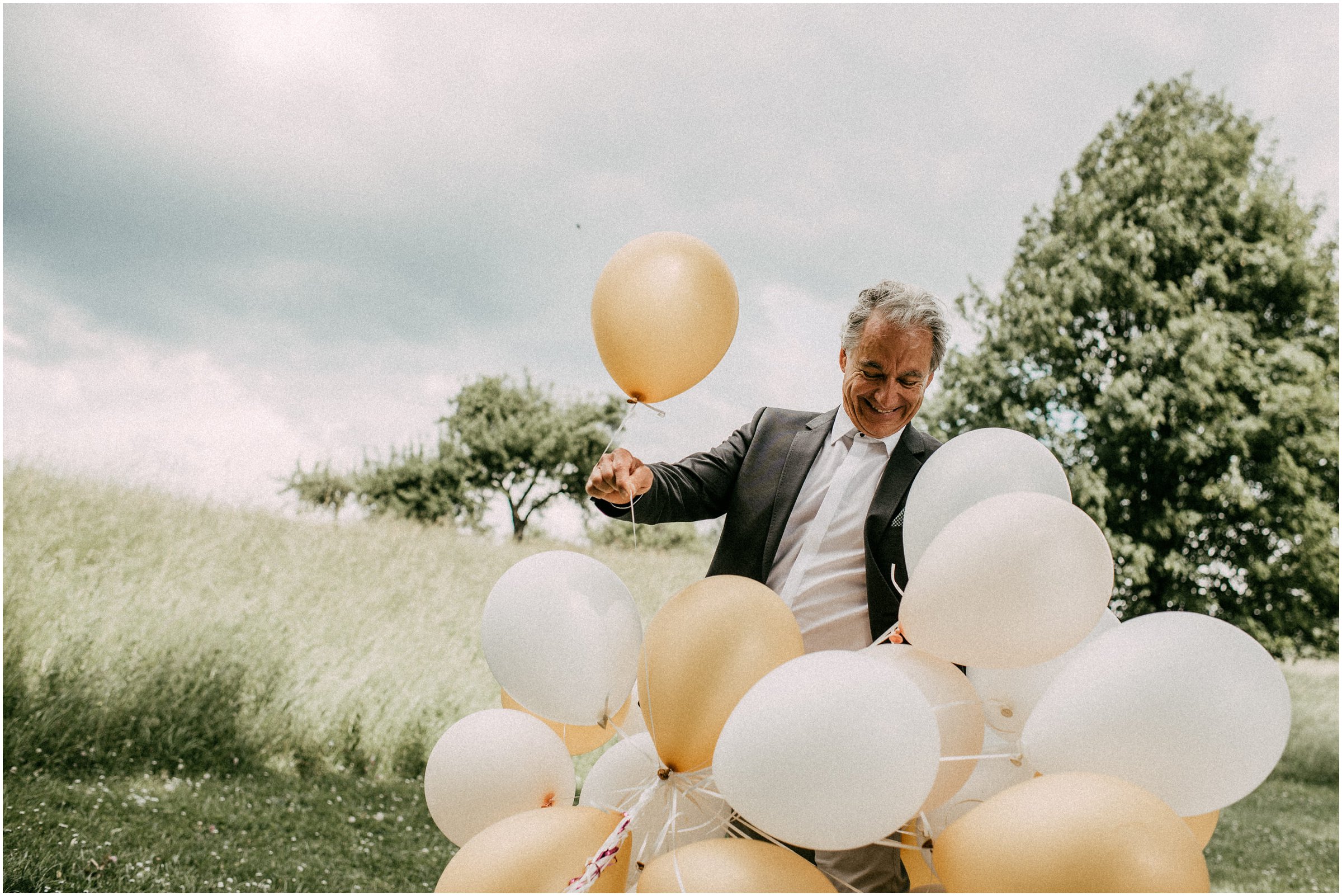 Wiesenhochzeit: Hochzeitsgast kämpft mit dem Wind und den Luftballons