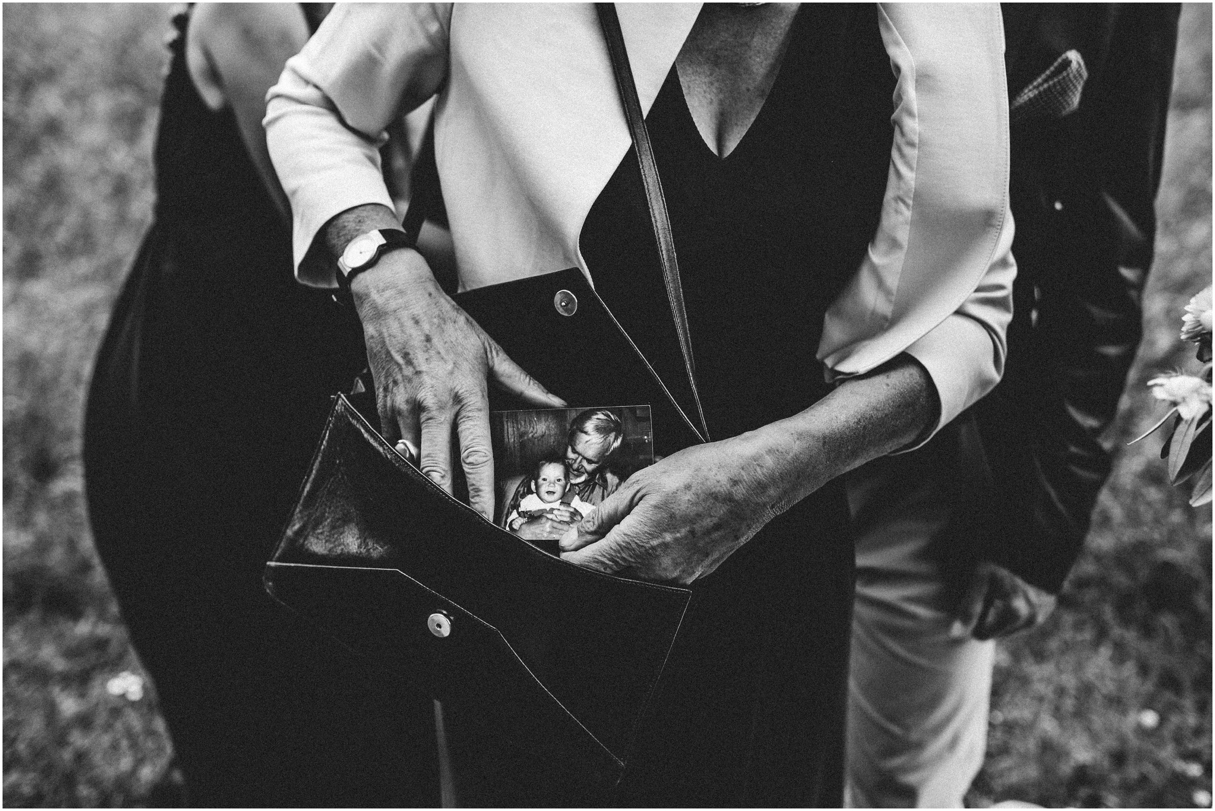 Wiesenhochzeit: eine Dame zieht ein altes Foto aus ihrer Handtasche