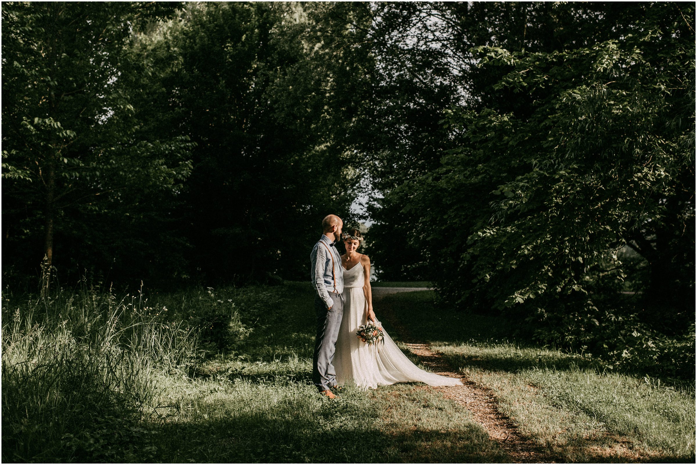 Wiesenhochzeit: Brautpaar Arm in Arm auf einer Wiese
