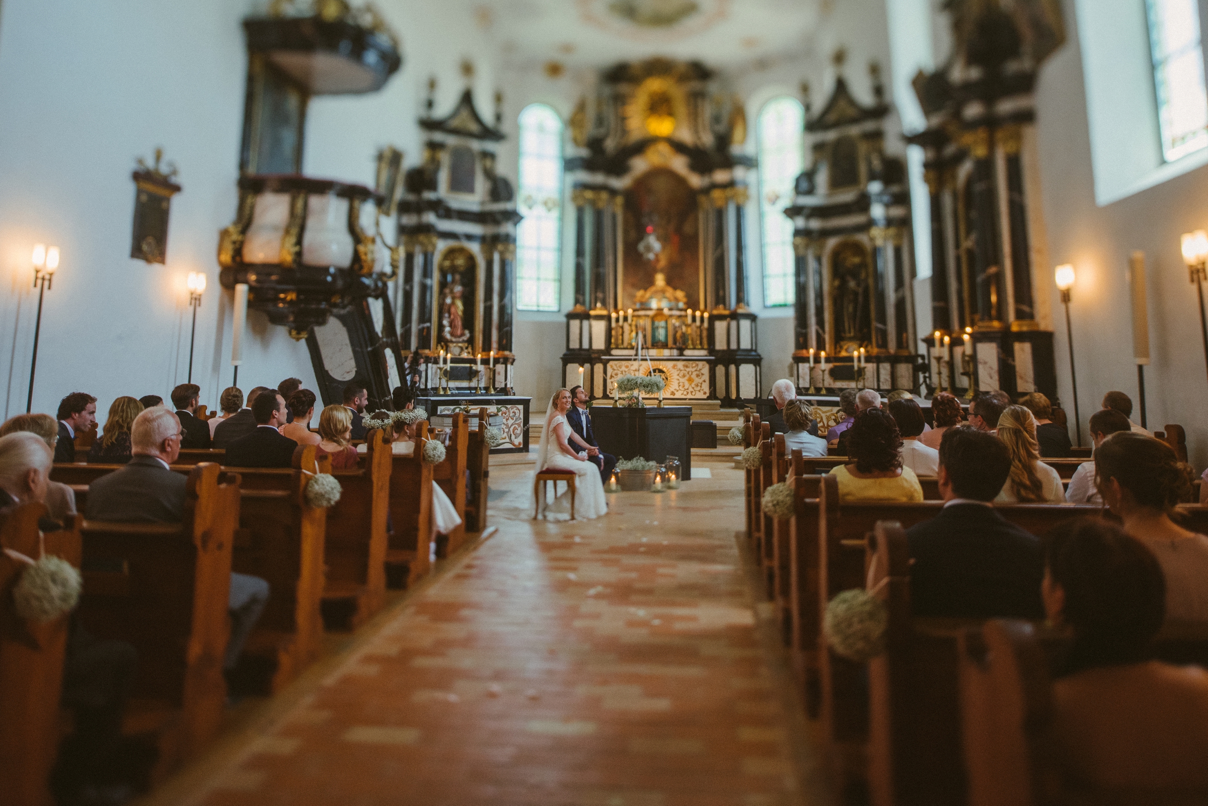 Hochzeit in der Schweiz: Panorama der Kirche mit Brautpaar sitzend vor dem Altar