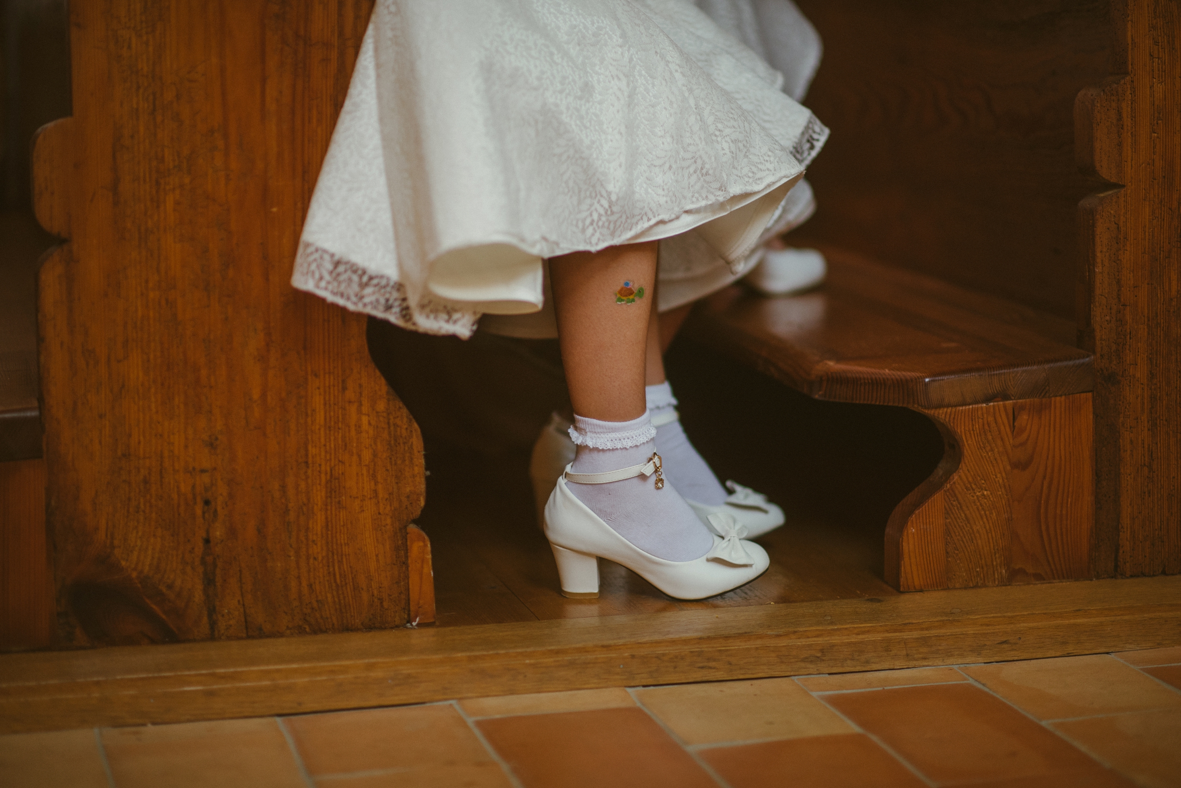 Hochzeit in der Schweiz: Nahaufnahme der Schuhe eines Gastes mit kleinem Tatoo am Bein