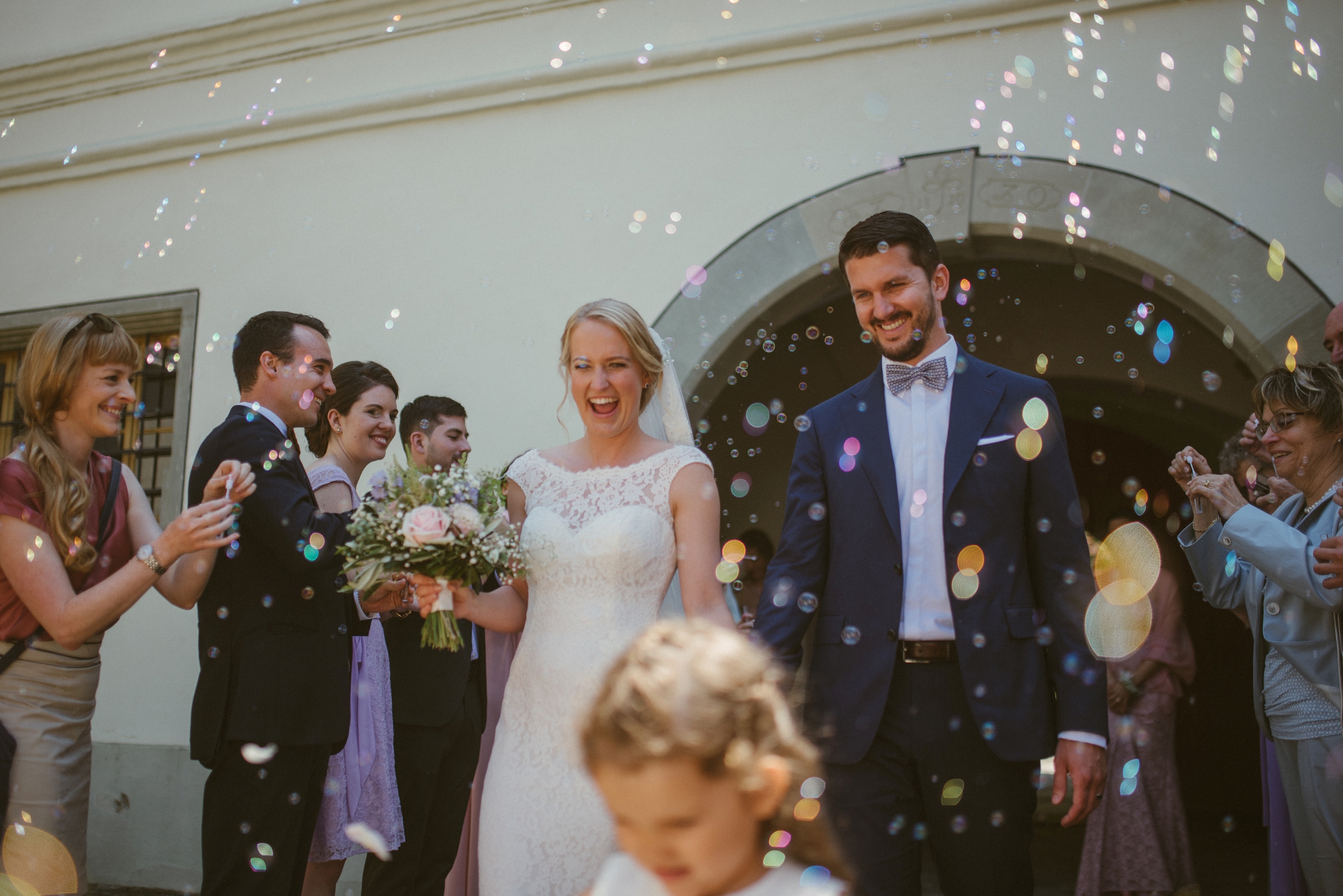 Hochzeit in der Schweiz: Brautpaar verlässt die Kirche, Gäste pusten Seifenblasen