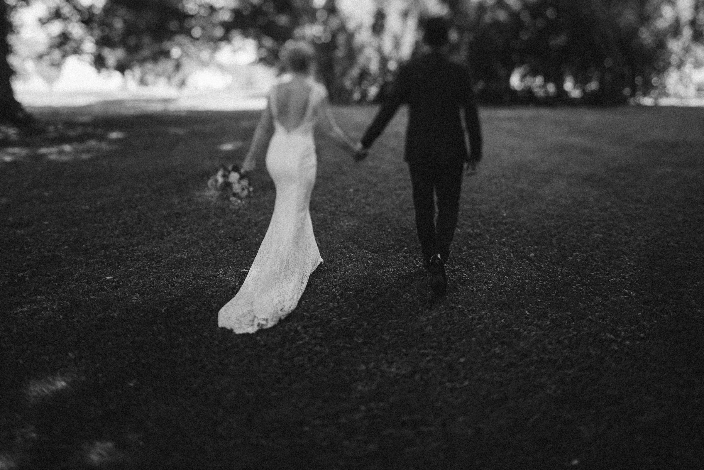 Hochzeit in der Schweiz: Rückenansicht des Brautpaars, gemeinsam Hand in Hand