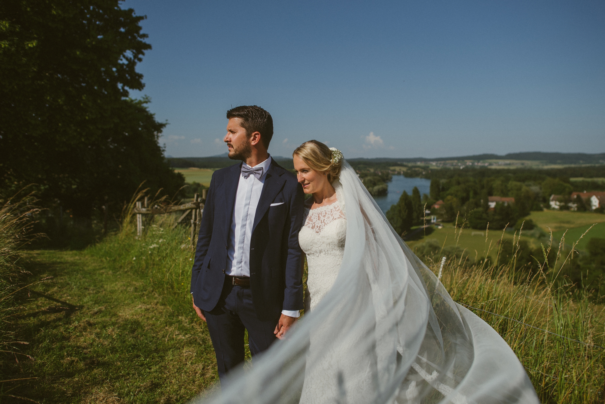 Hochzeit in der Schweiz: Brautpaar-Portrait, der Schleier der Braut weht in die Kamera