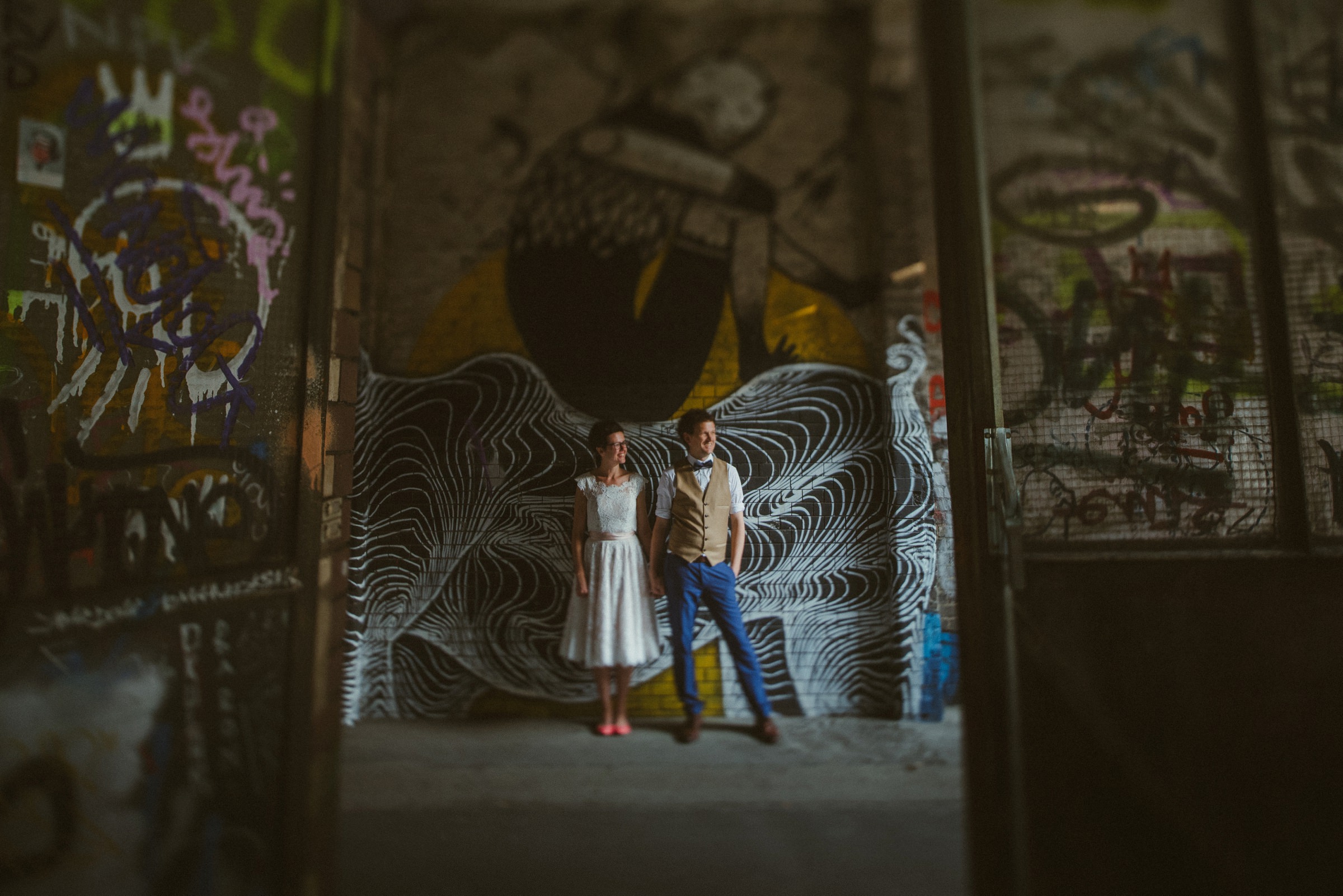 Hochzeit in Berlin: Brautpaar vor mit Graffiti verschönerter Wand