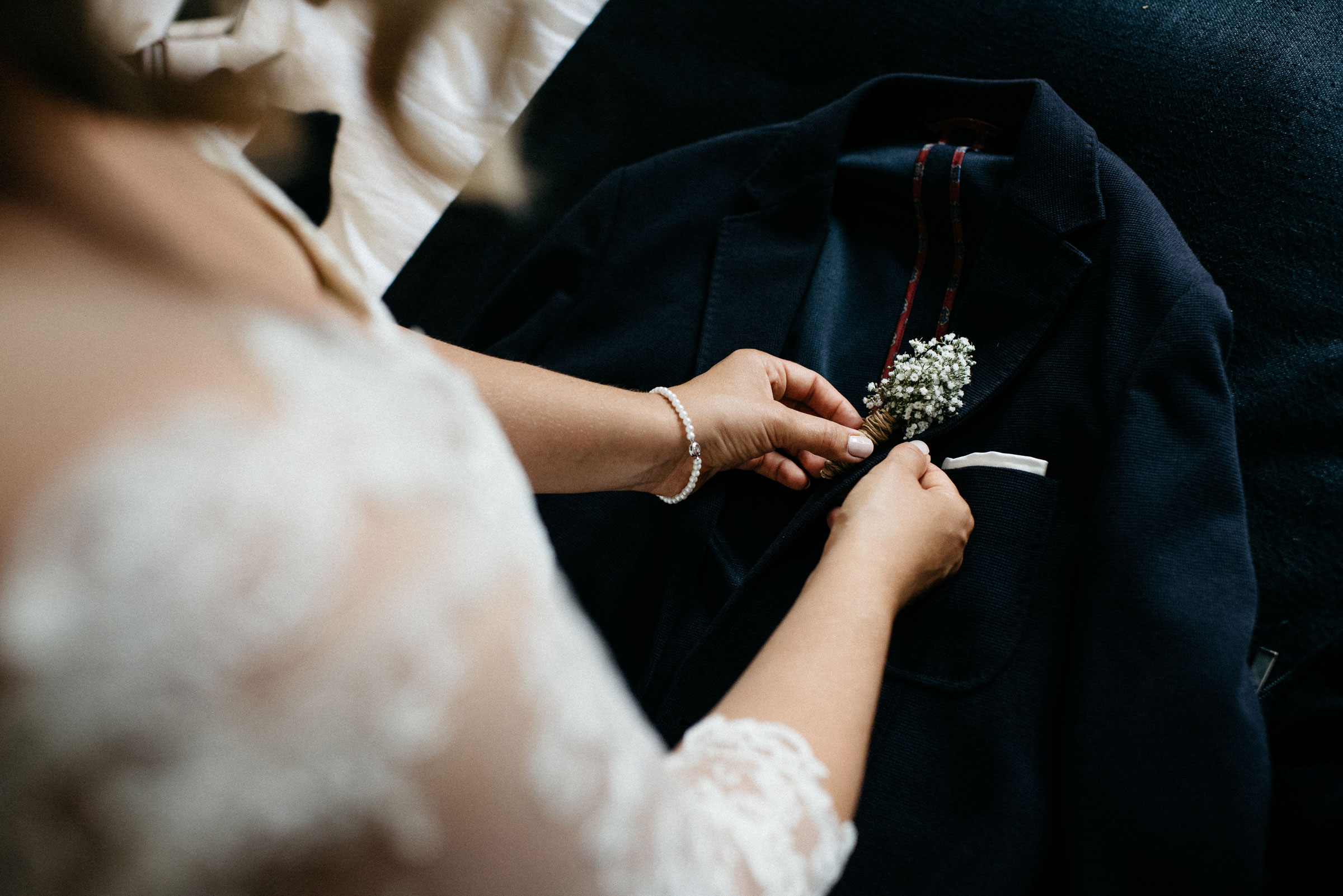 finnische Hochzeit: die Braut steckt dem Bräutigam das Gesteck an