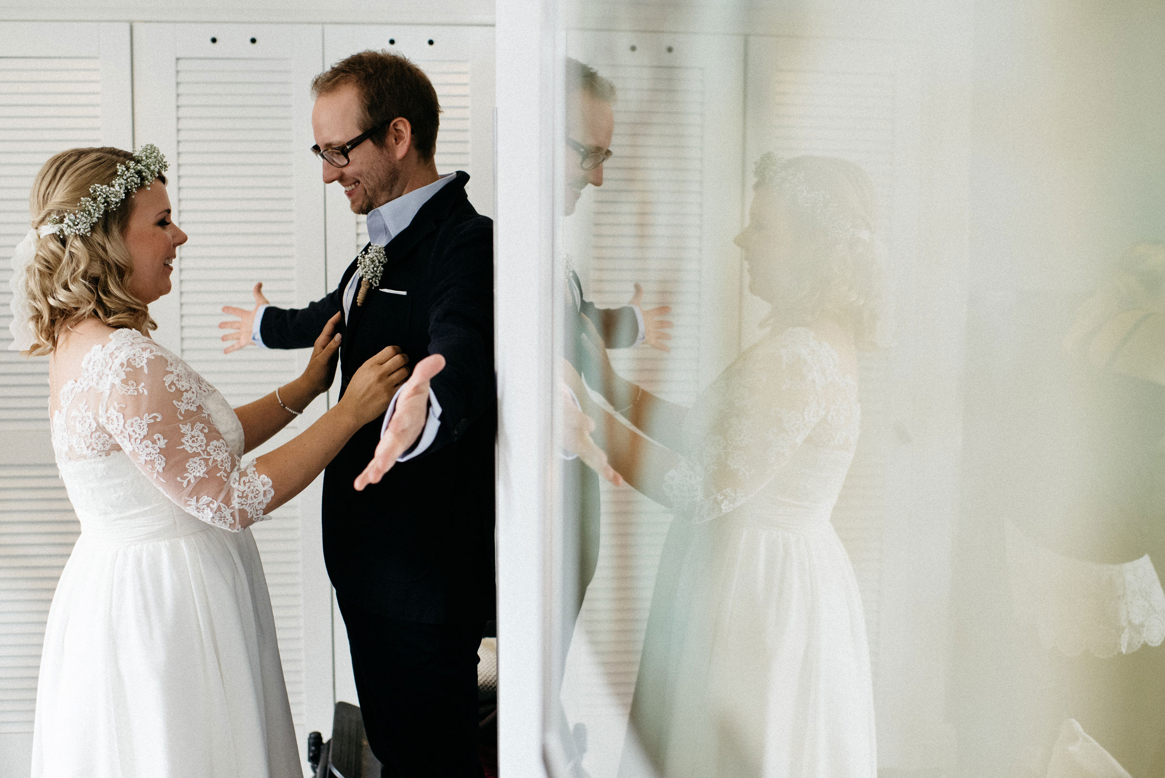 finnische Hochzeit: die Braut richtet ihrem Bräutigam den Anzug