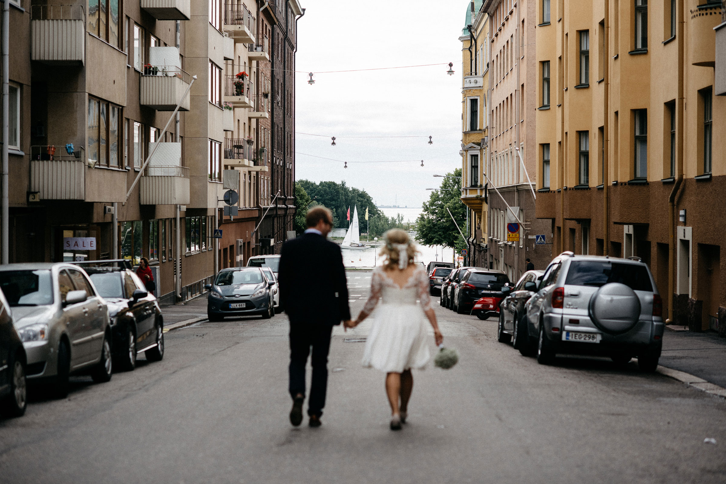 finnische Hochzeit: das Hochzeitspaar läuft Hand in Hand durch Helsinki
