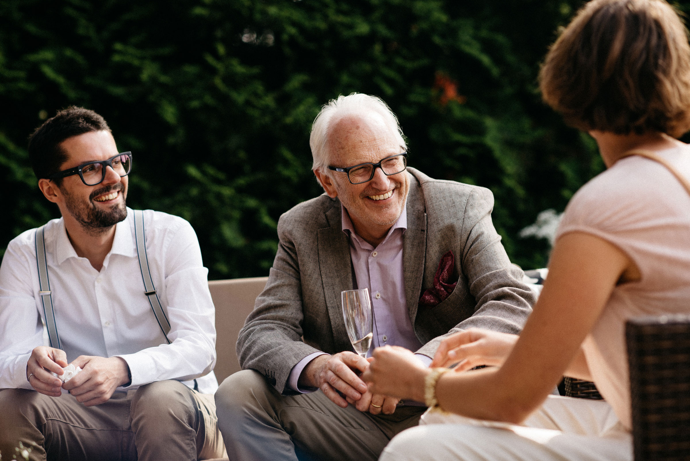 finnische Hochzeit: ein lachender Hochzeitsgast mit Sektglas