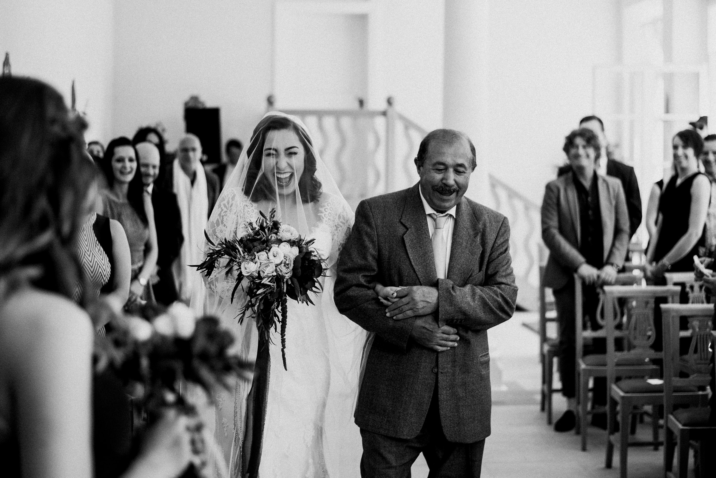 Deutsch-türkische Hochzeit: Braut mit dem Vater auf dem Weg zum Altar, sie lacht
