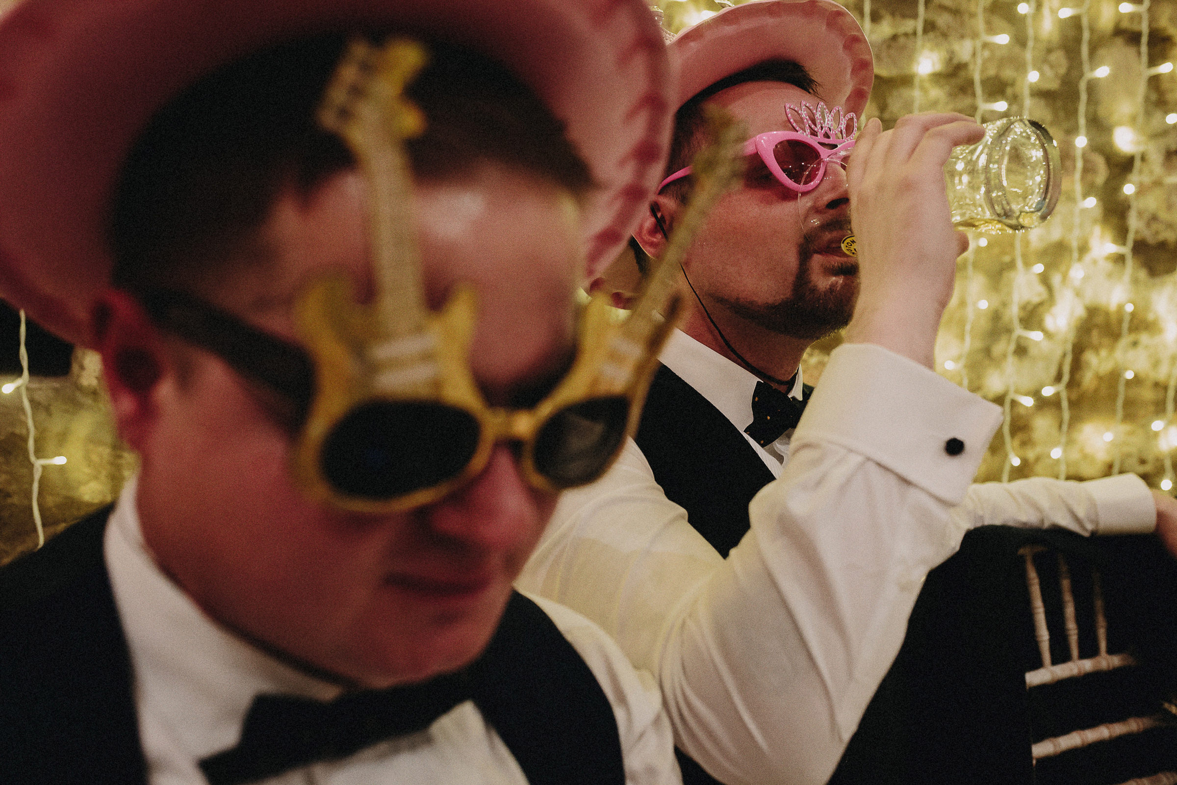 Britische Hochzeit: trinkender Hochzeitsgast mit Party-Hut und Spaß-Brille