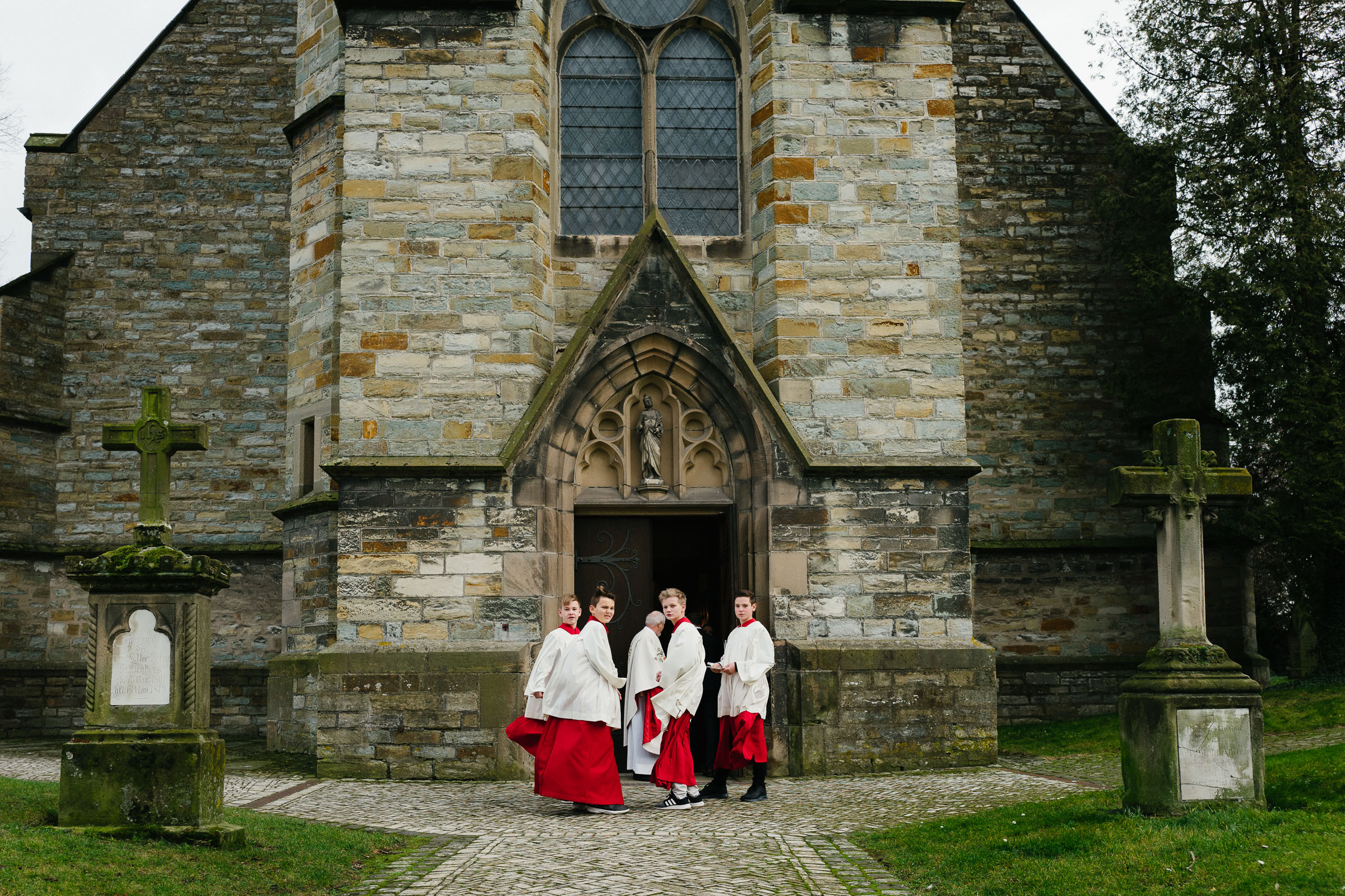 die Kirche der Silvester-Hochzeit, am Eingang die Messdiener mit rot-weißen Gewändern