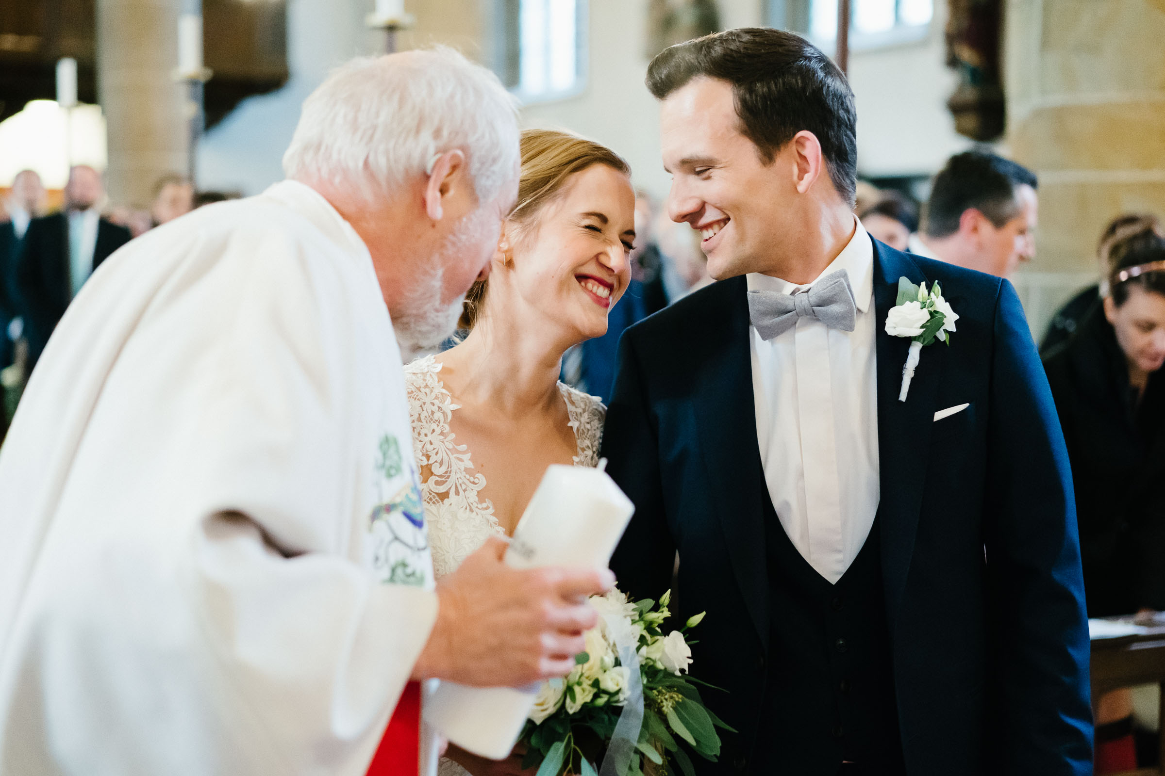 lachendes Brautpaar der Silvester-Hochzeit mit Geistlichen