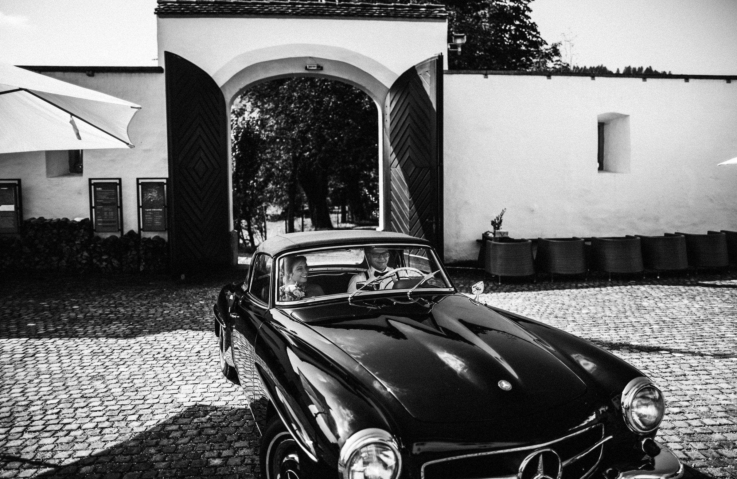 Schlosshochzeit: Brautpaar in Oldtimer