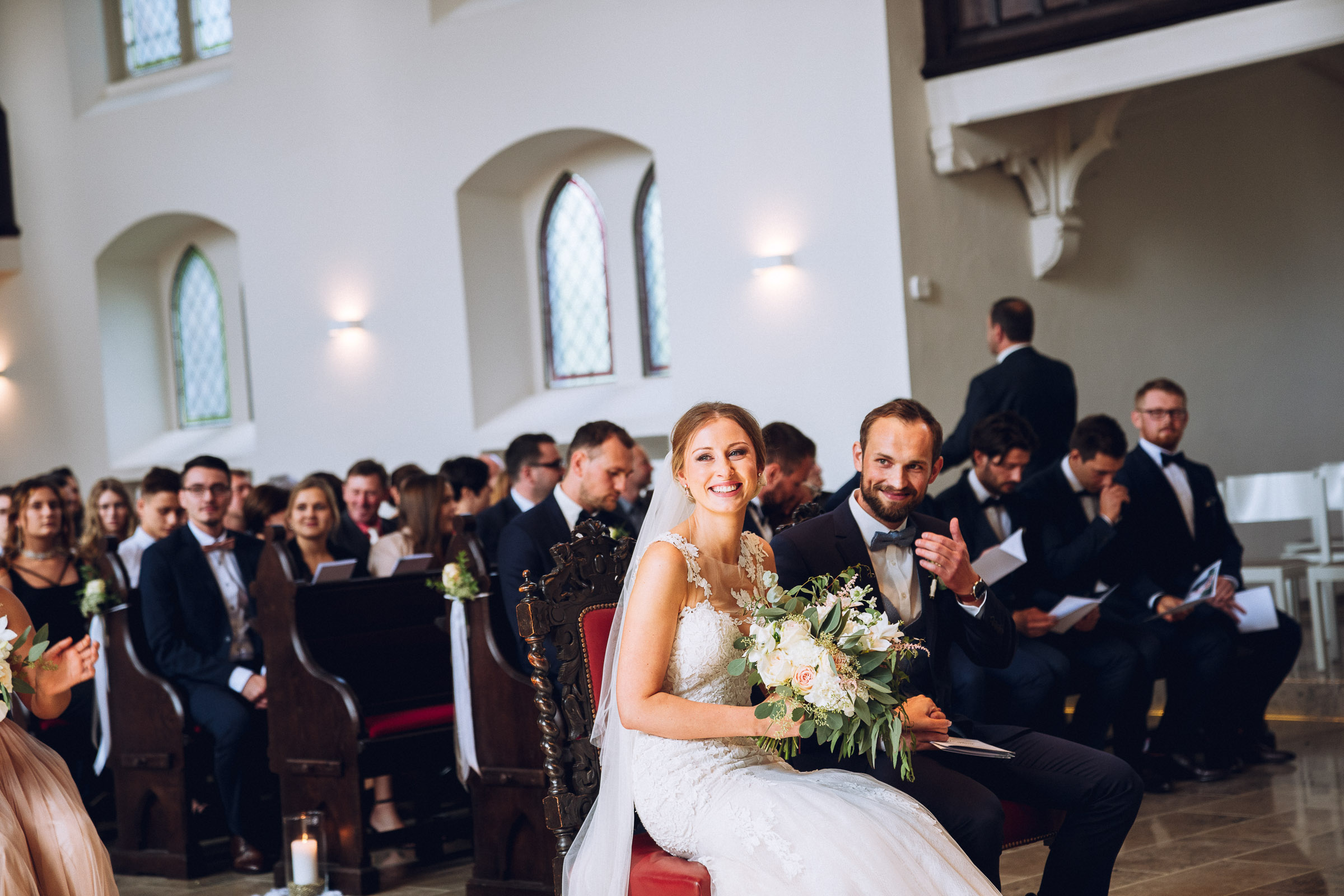 Septemberhochzeit: lachendes Hochzeitspaar in der Kirche vor dem Altar