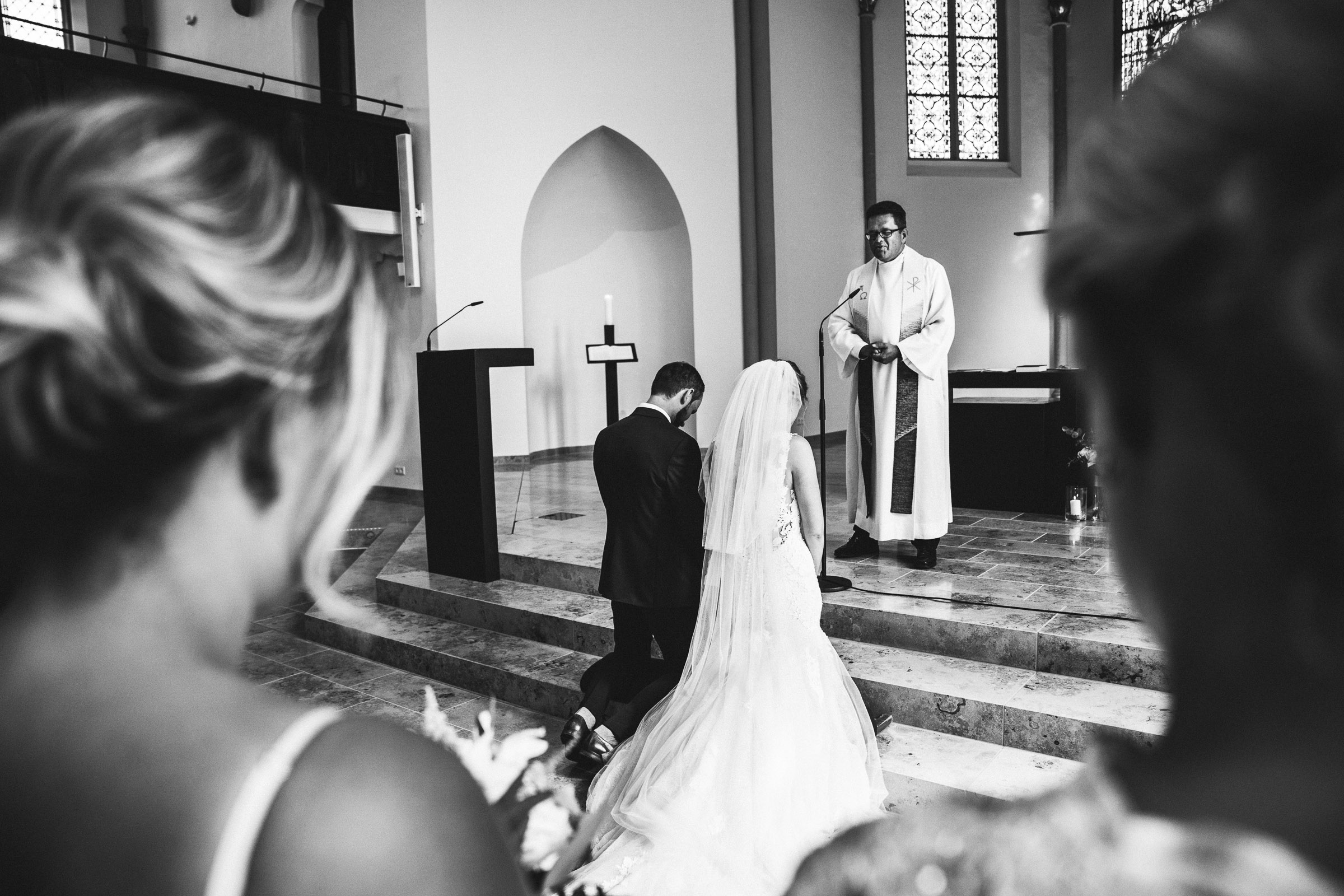 Septemberhochzeit: Brautpaar kniet vor Altar