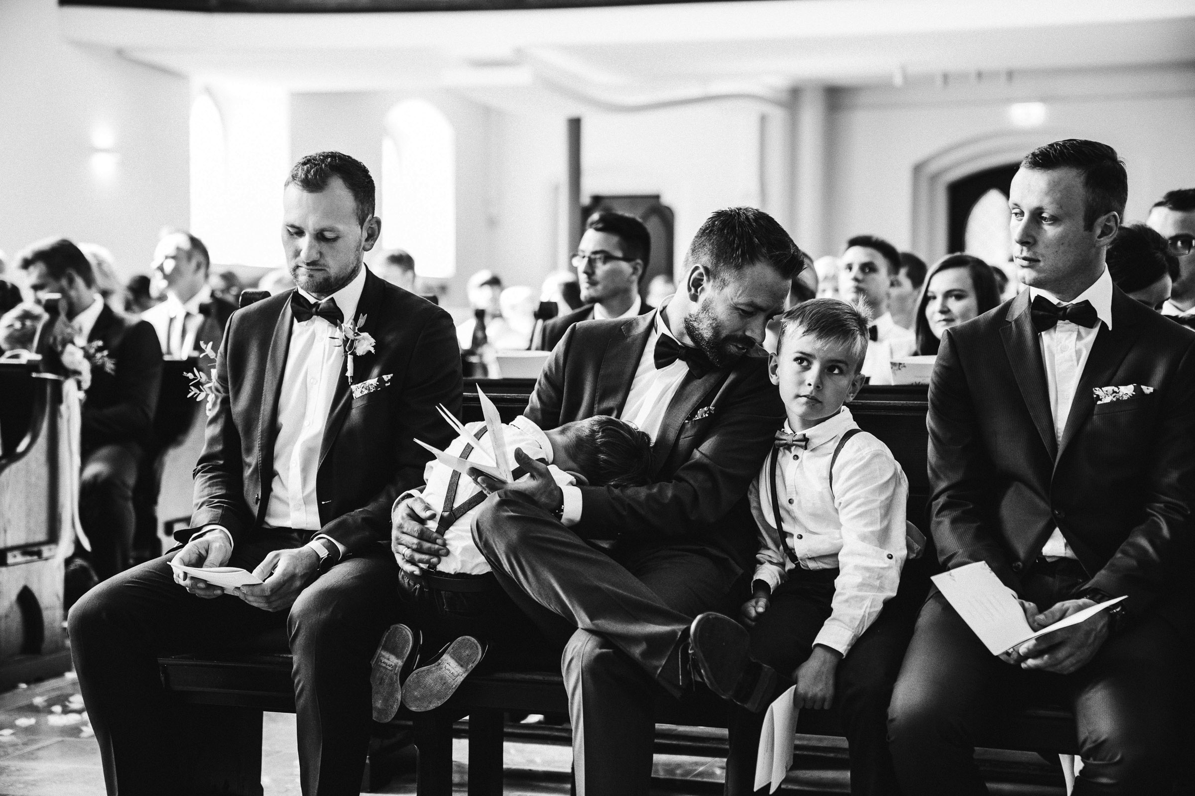 Septemberhochzeit: Hochzeitsgast flüstert einem Kind etwas ins Ohr