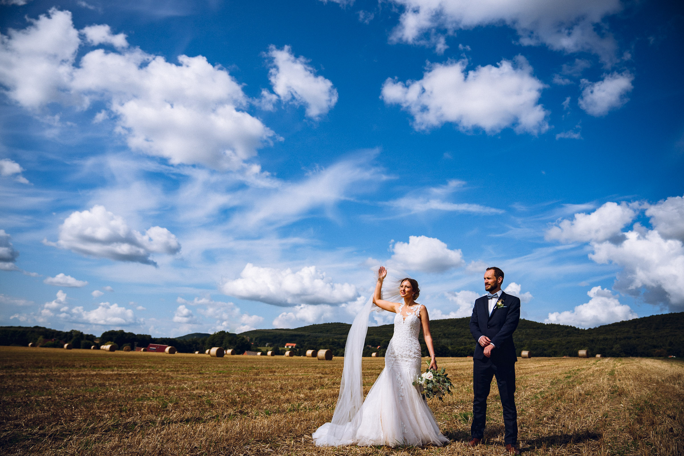 Septemberhochzeit: Brautpaar auf einem gemähten Feld