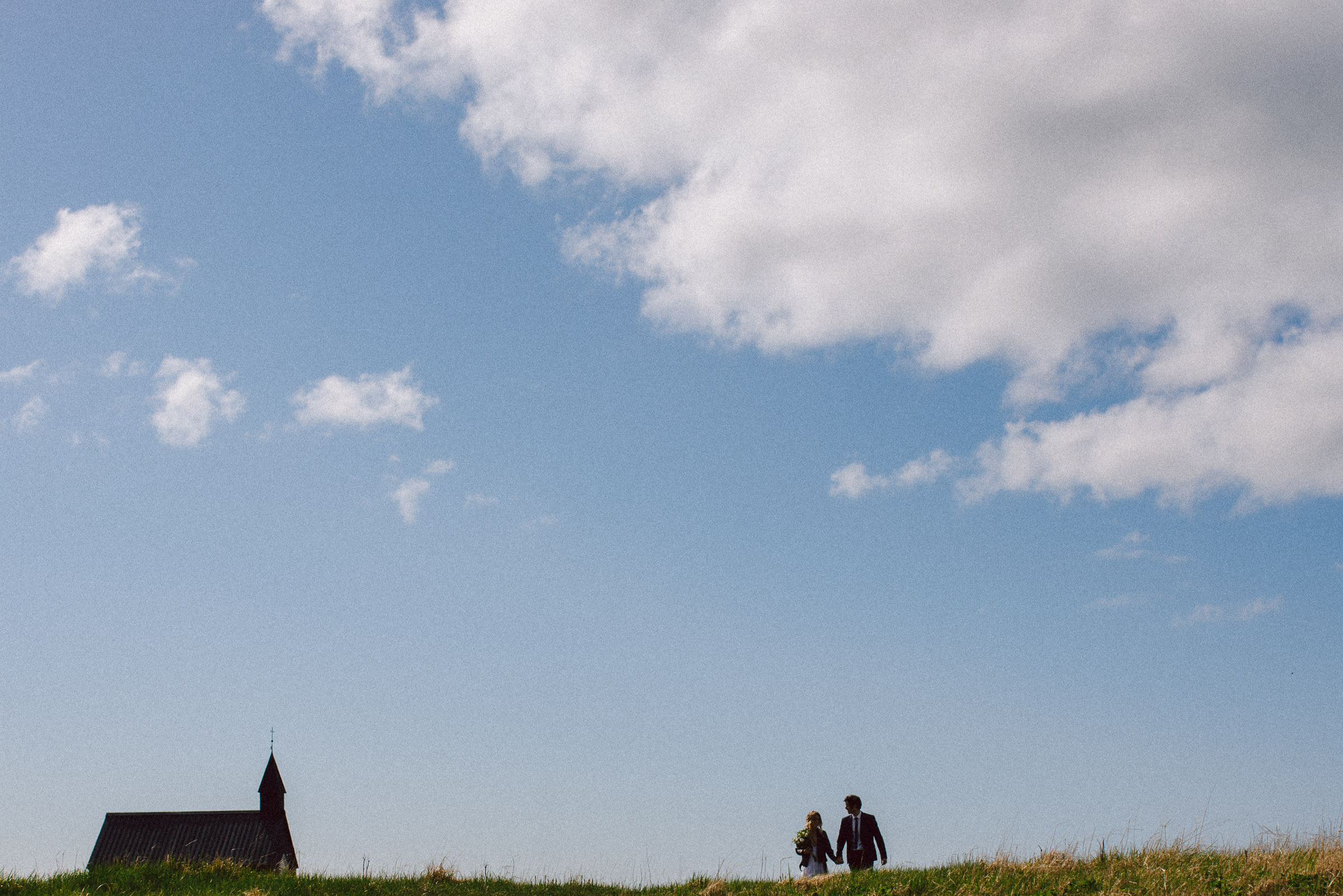 Island-Hochzeit: Brautpaar und im Hintergrund die Budir Kirche