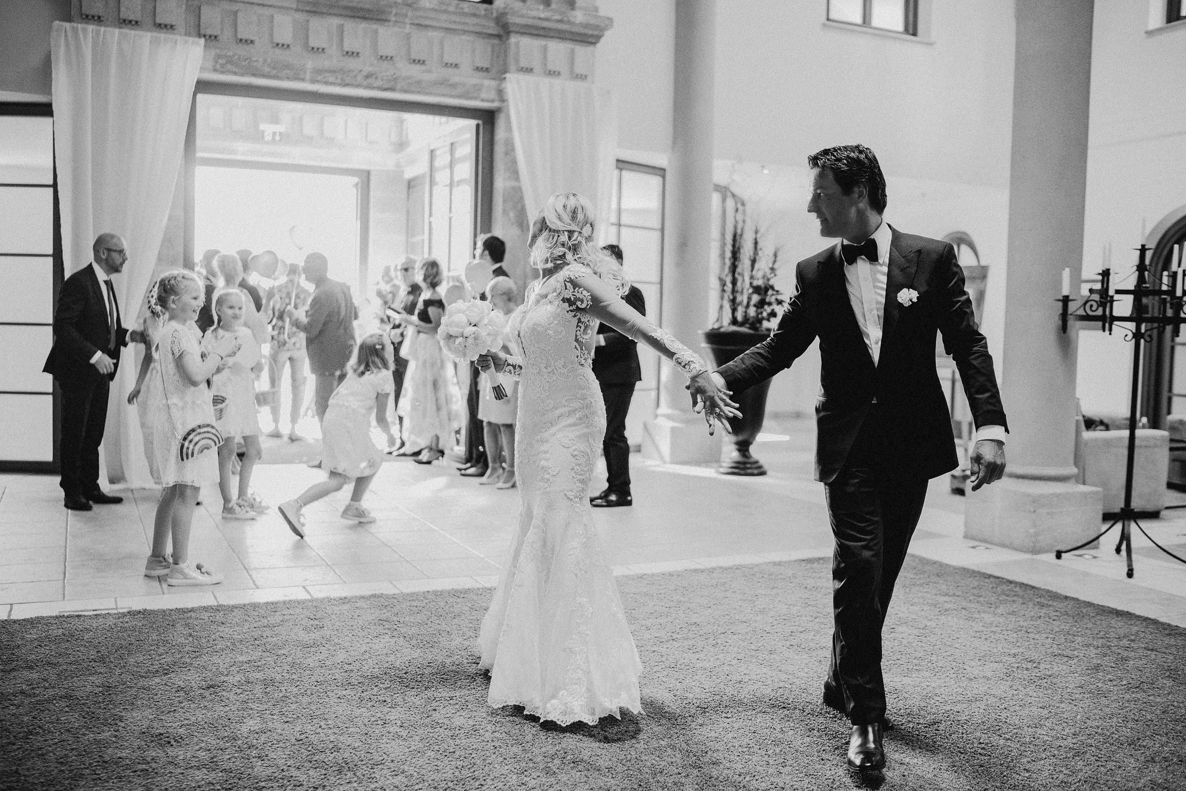 Alpenhochzeit: das Brautpaar läuft Hand in Hand in das Hotel ein