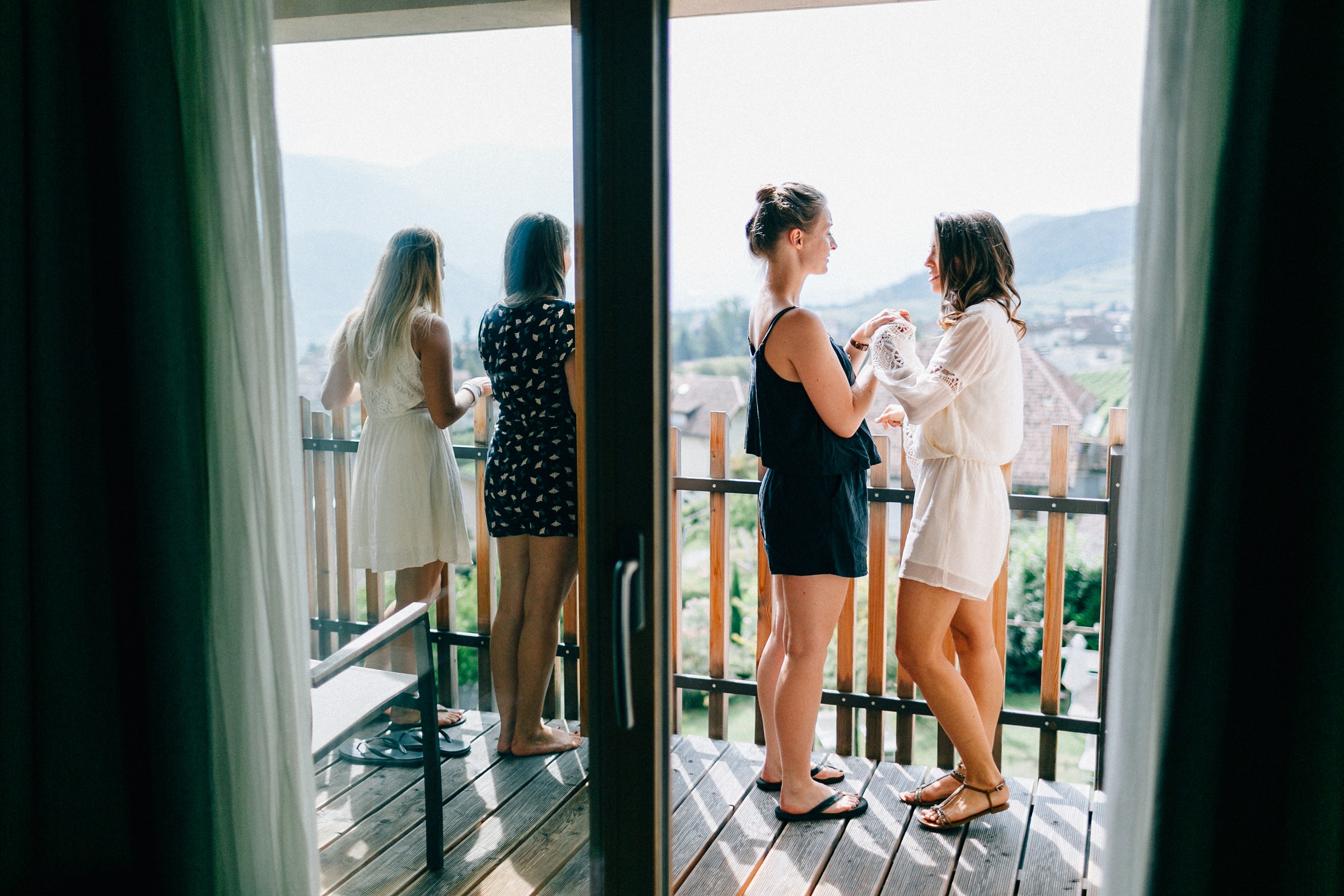 die Freundinnen und die Braut der mediterranen Hochzeit auf dem Balkon des Hotelzimmers
