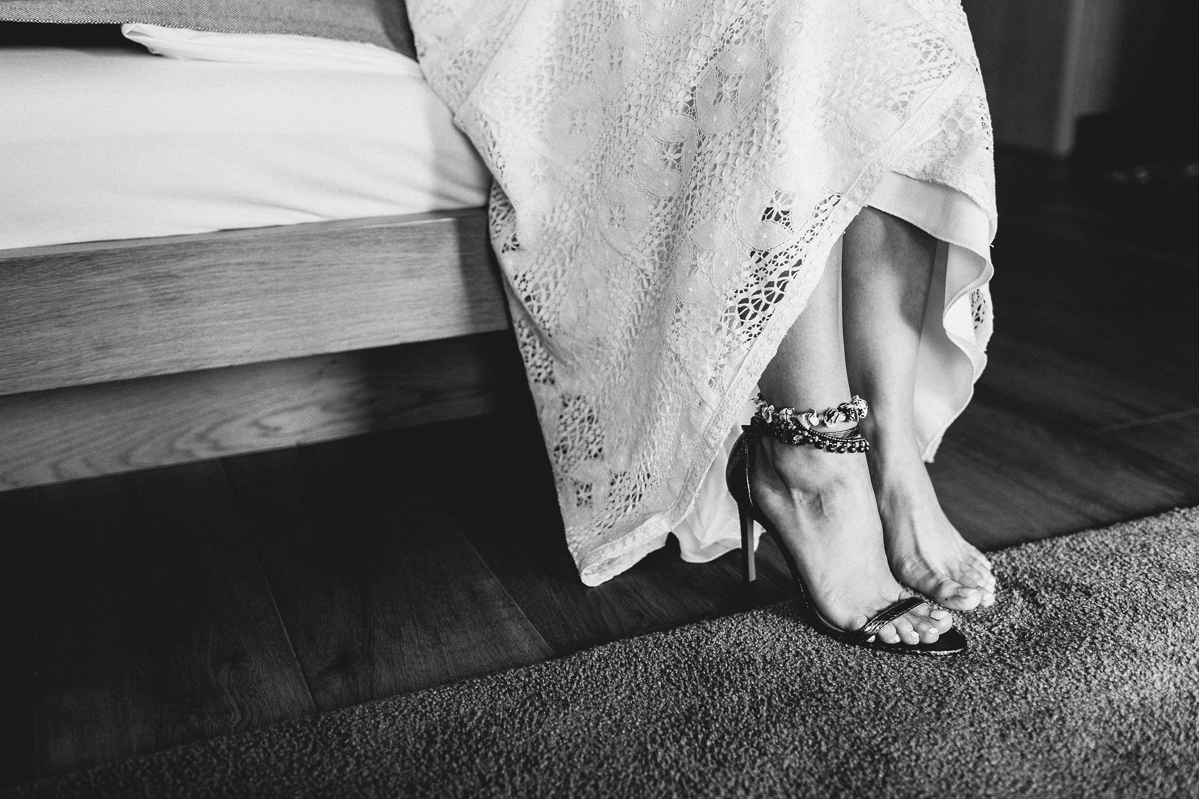 die Füße der Braut der mediterranen Hochzeit mit nur einem Schuh