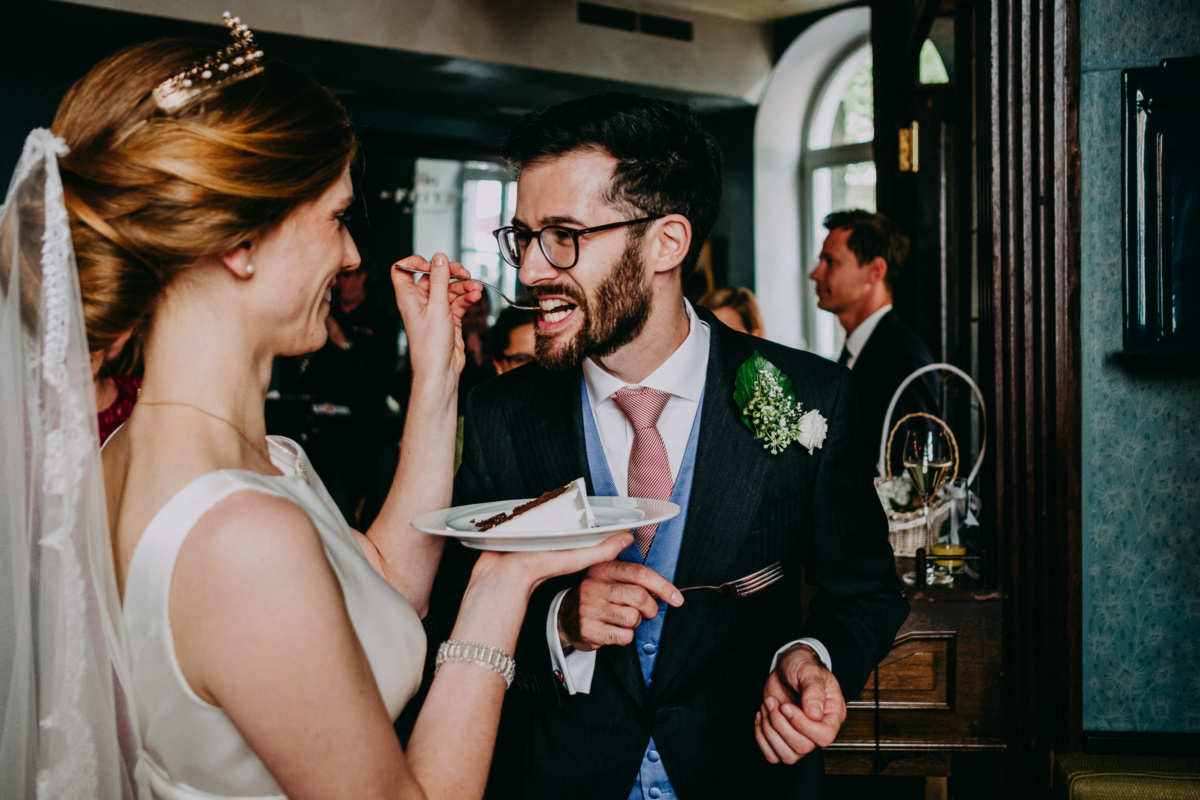 Hochzeit in der Alten Gärtnerei: Braut füttert dem Bräutigam ein Stück Hochzeitstorte