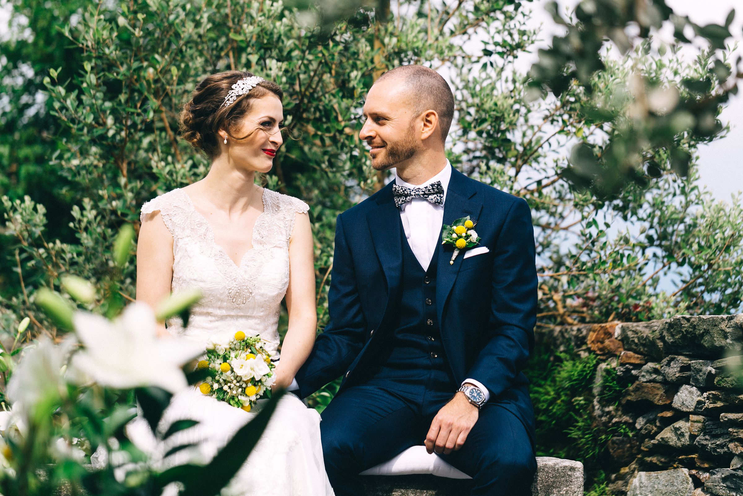 Hochzeit auf einer Insel: das Brautpaar hält Händchen und lächelt sich an