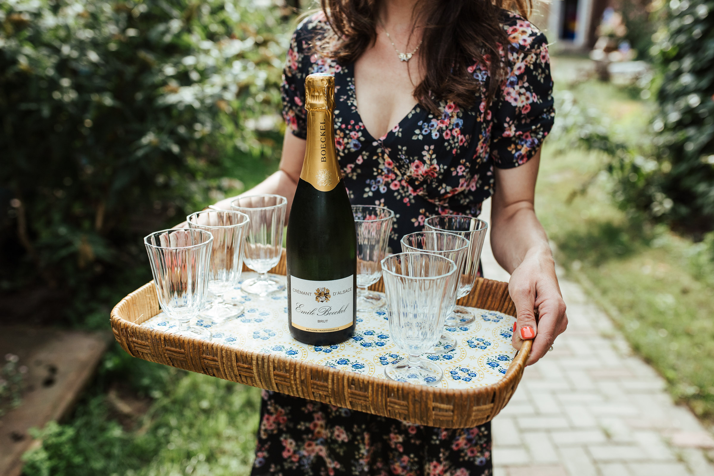 eine Frau bringt Champagner zum Sektempfang der Scheunenhochzeit