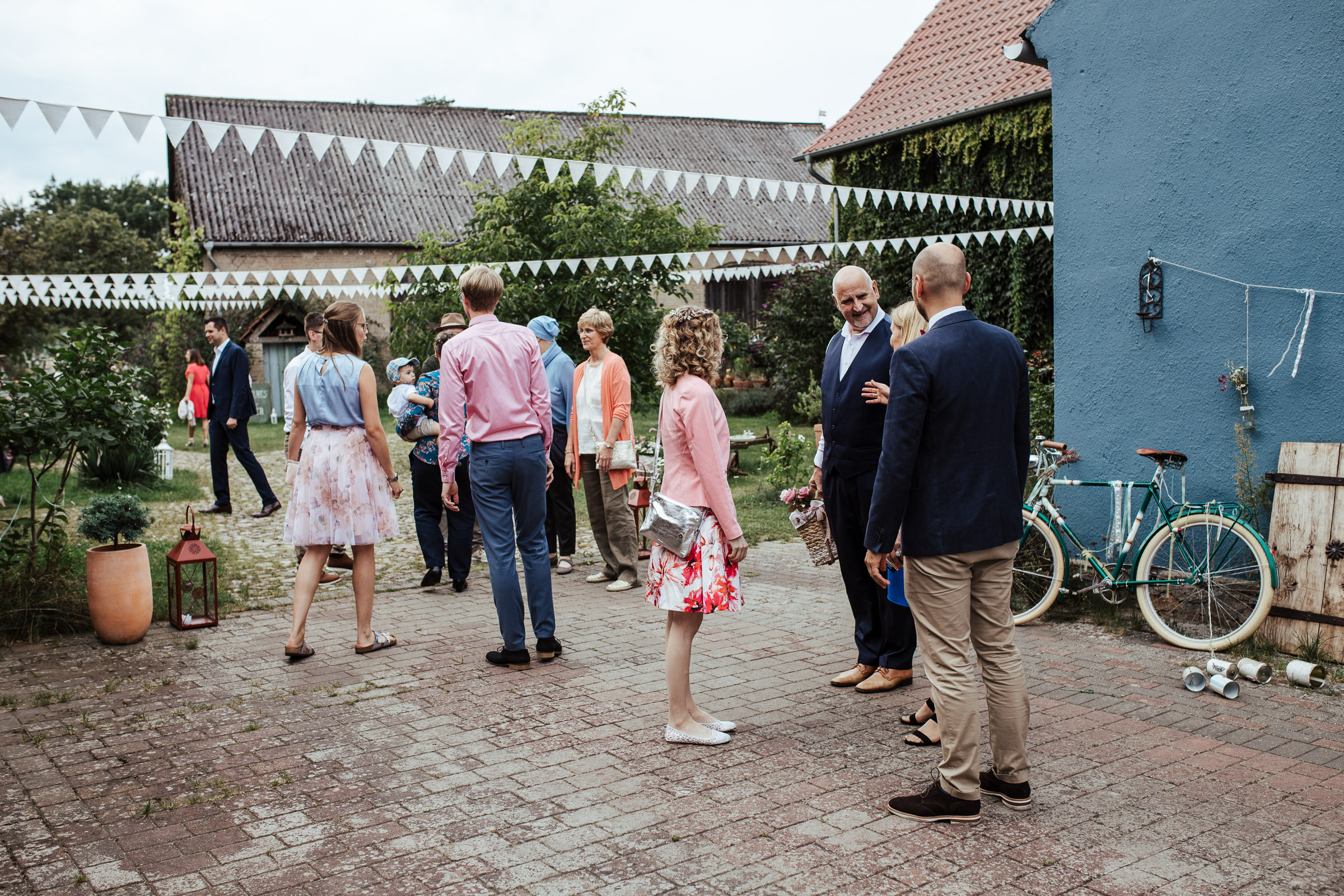Gäste der Scheunenhochzeit versammeln sich auf dem Hof