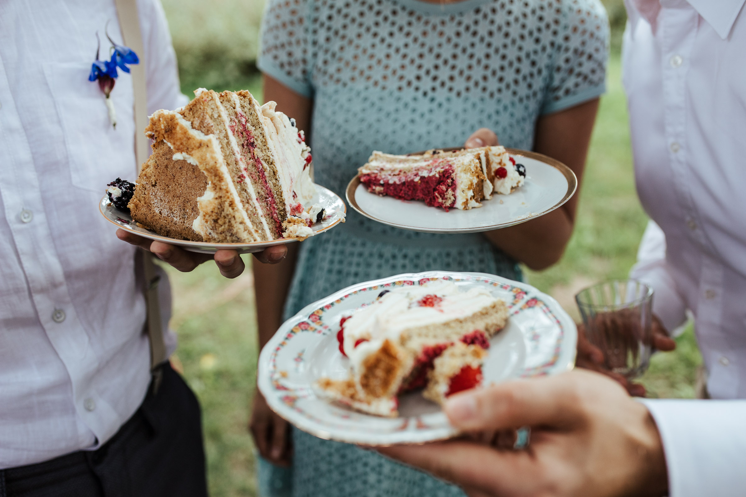 Gäste der Scheunenhochzeit mit großen Kuchenstücken auf den Tellern