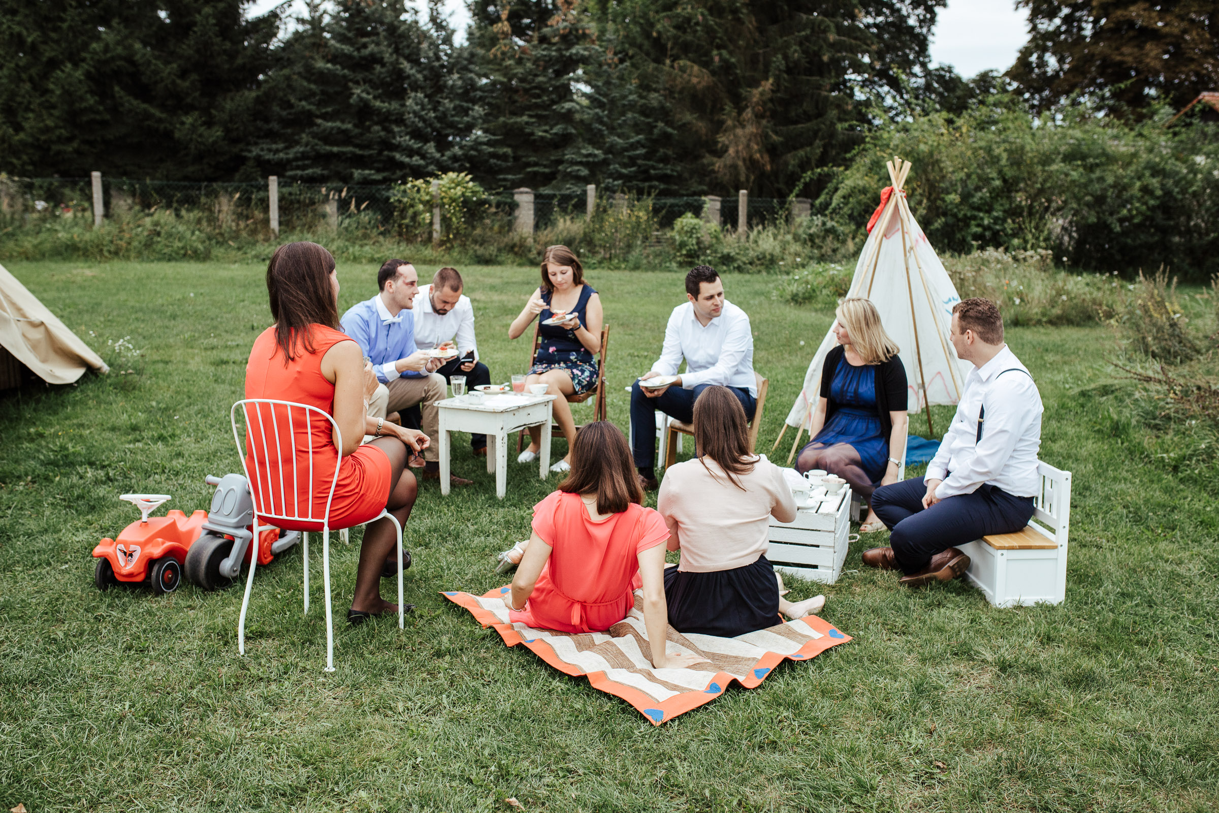 Gäste der Scheunenhochzeit im Garten, im Hintergrund ein Tipi