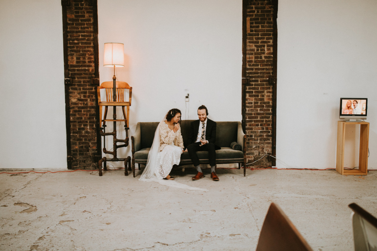 Hochzeit in New York - Brautpaar sitzt auf einem Sofa und hört Musik