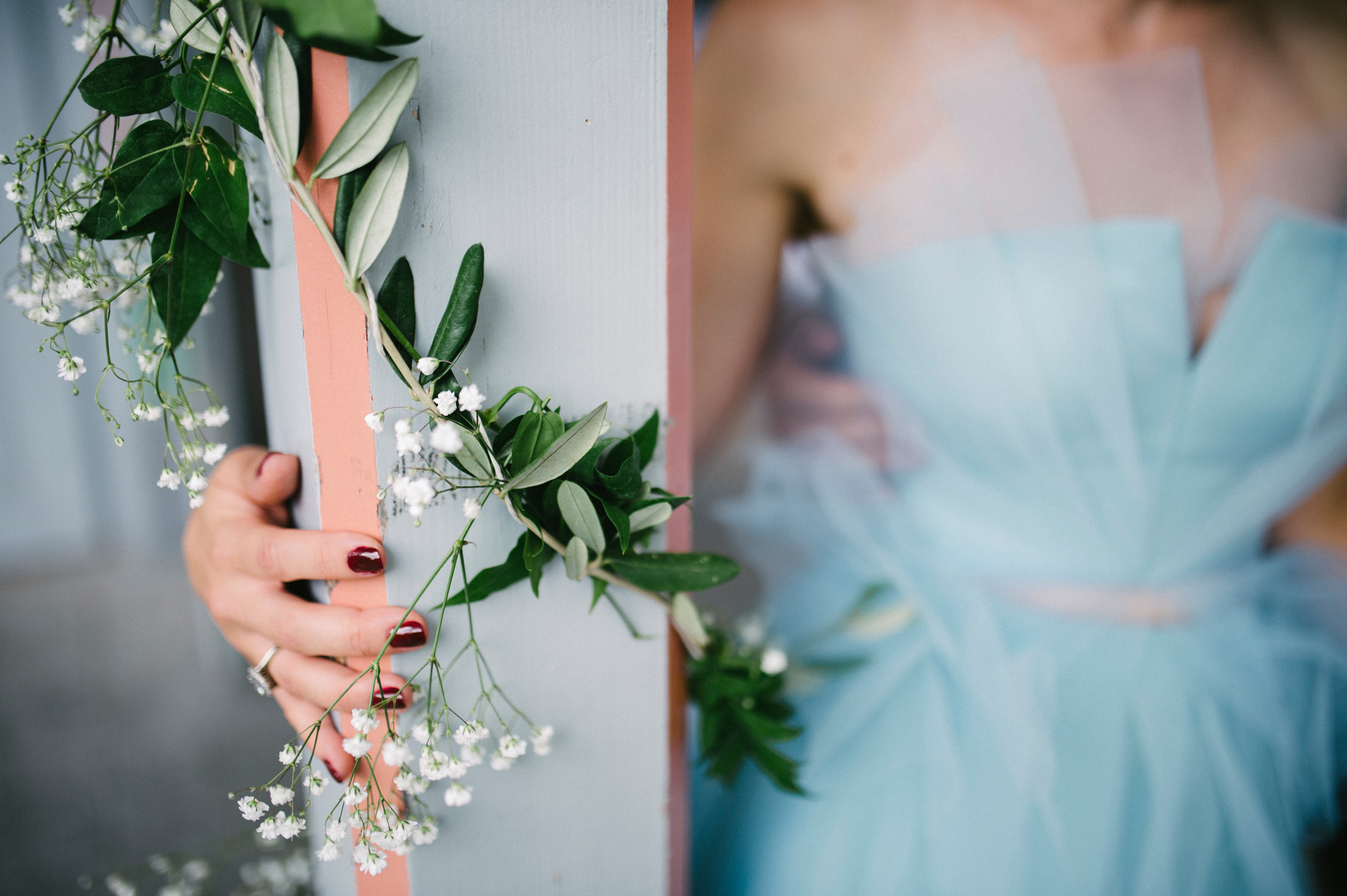 Berghochzeit: Detailaufnahme der Hand der Braut und Blumenschmuck der Location