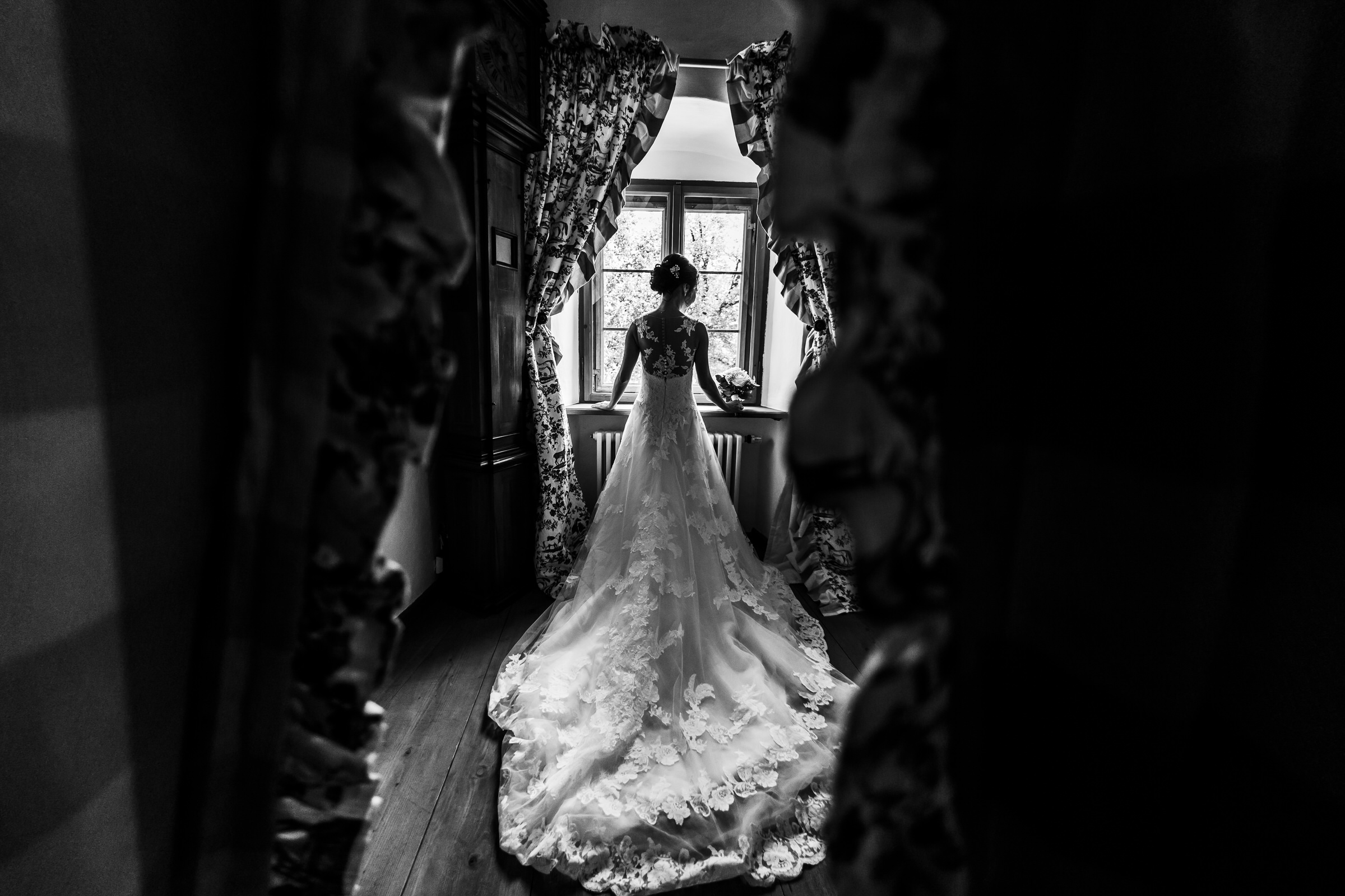 deutsch-chinesische Hochzeit: Braut vor dem Fenster im Hotelzimmer