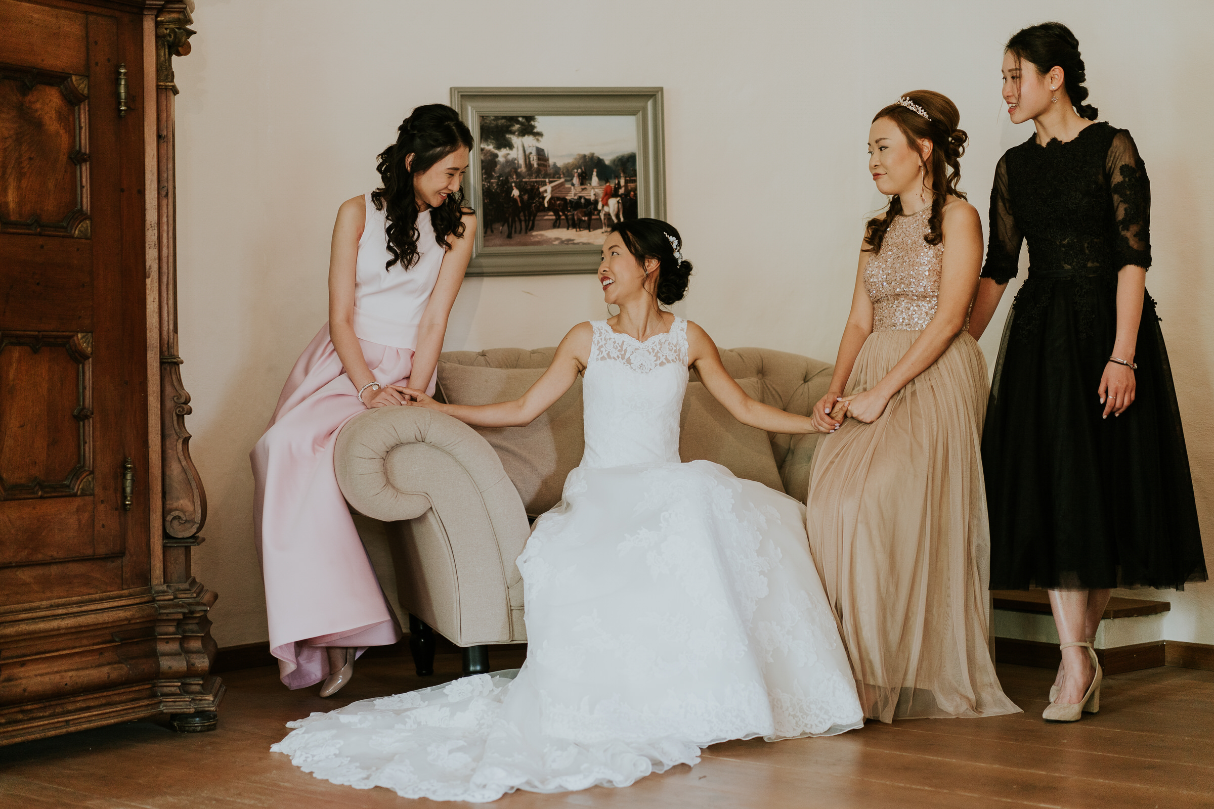 deutsch-chinesische Hochzeit: Braut im Hotelzimmer umrahmt von ihren Brautjungfern