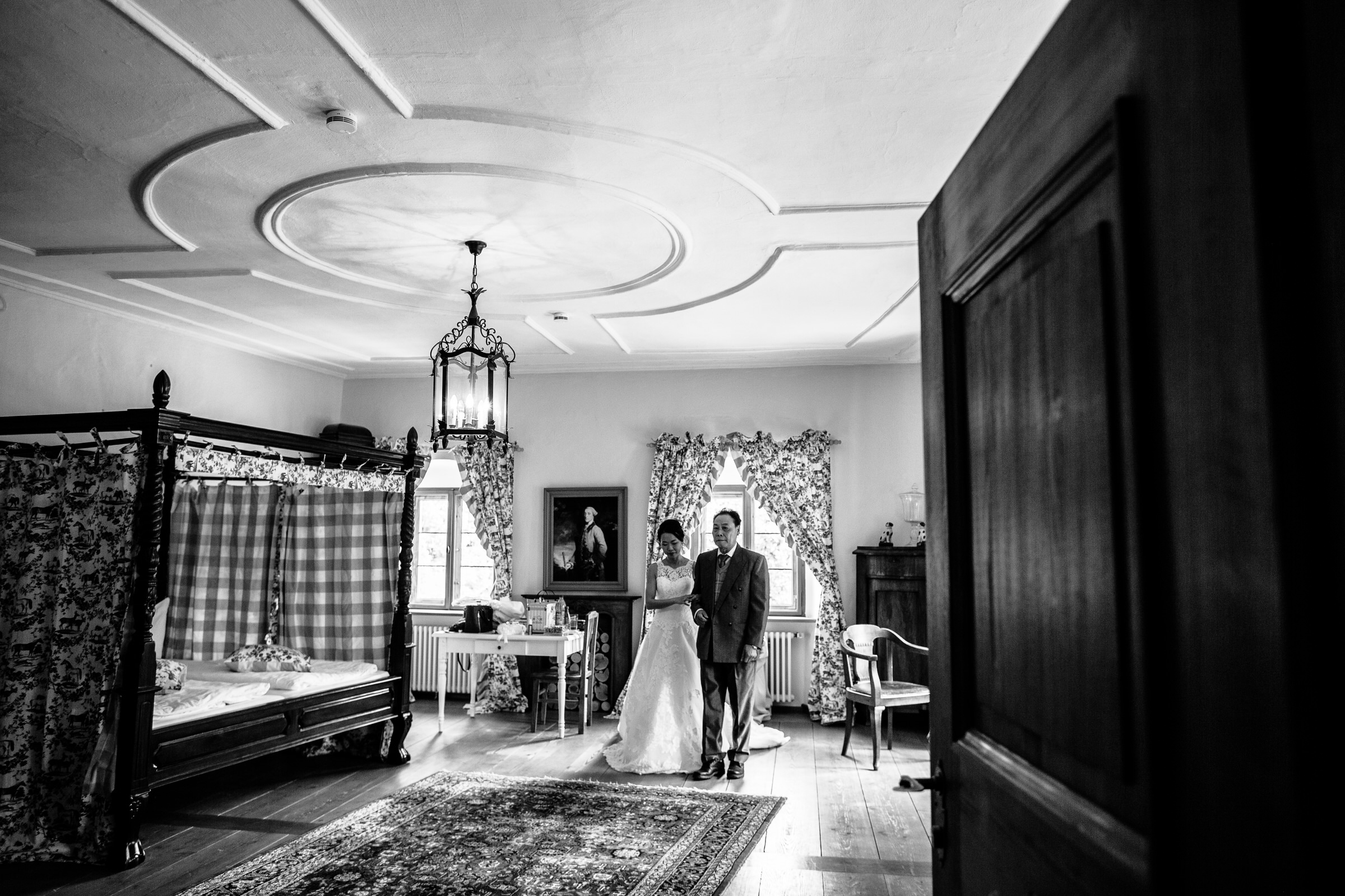 deutsch-chinesische Hochzeit: Braut verlässt am Arm des Brautvaters das Hotelzimmer
