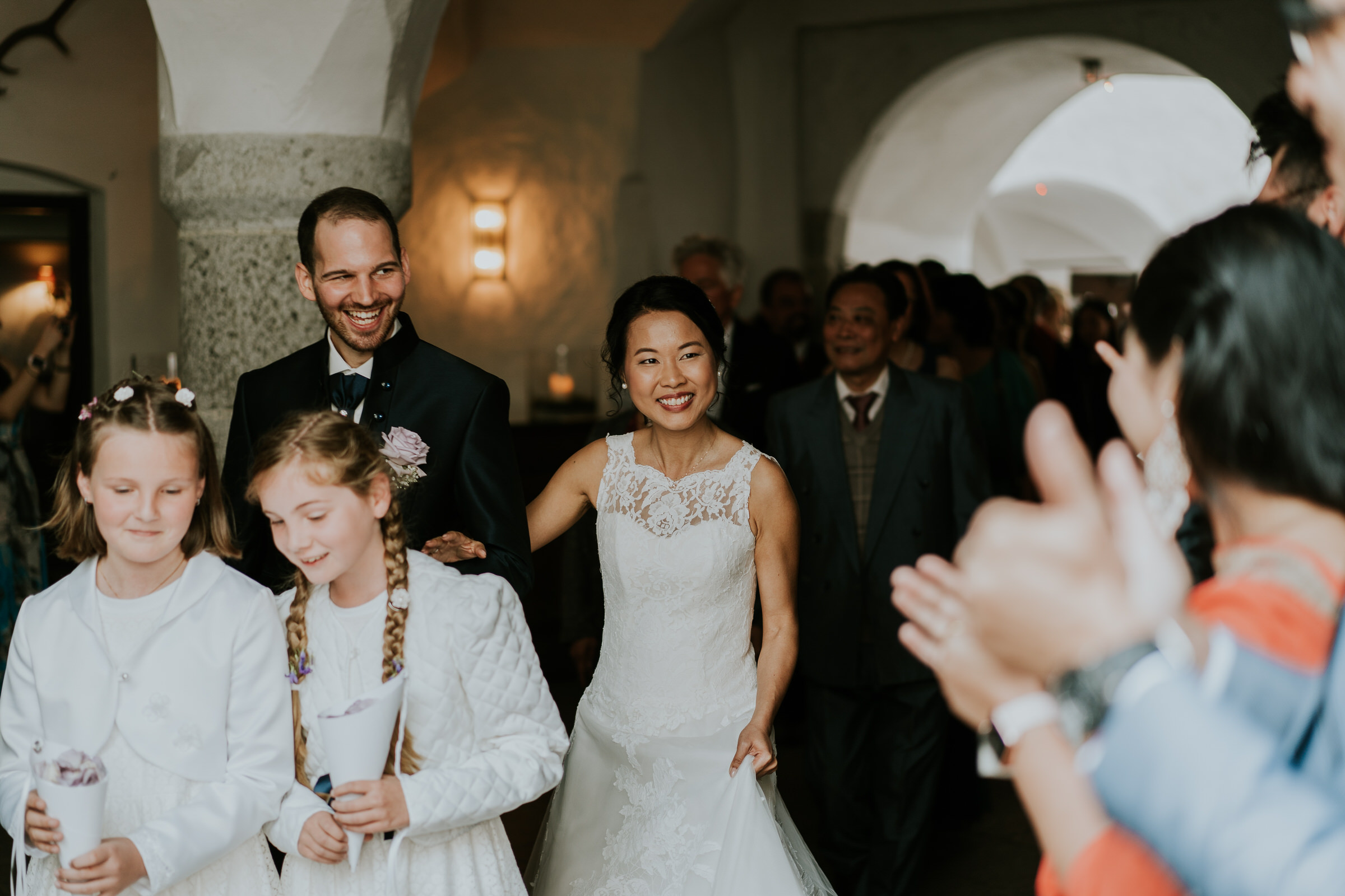 Deutsch-chinesische Hochzeit: Brautpaar läuft durch das Spalier der klatschenden Hochzeitsgäste