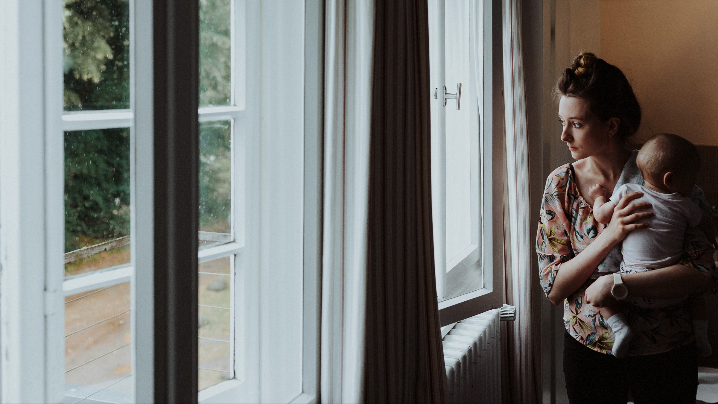 Waldhochzeit: Hochzeitsgast mit Baby am Fenster