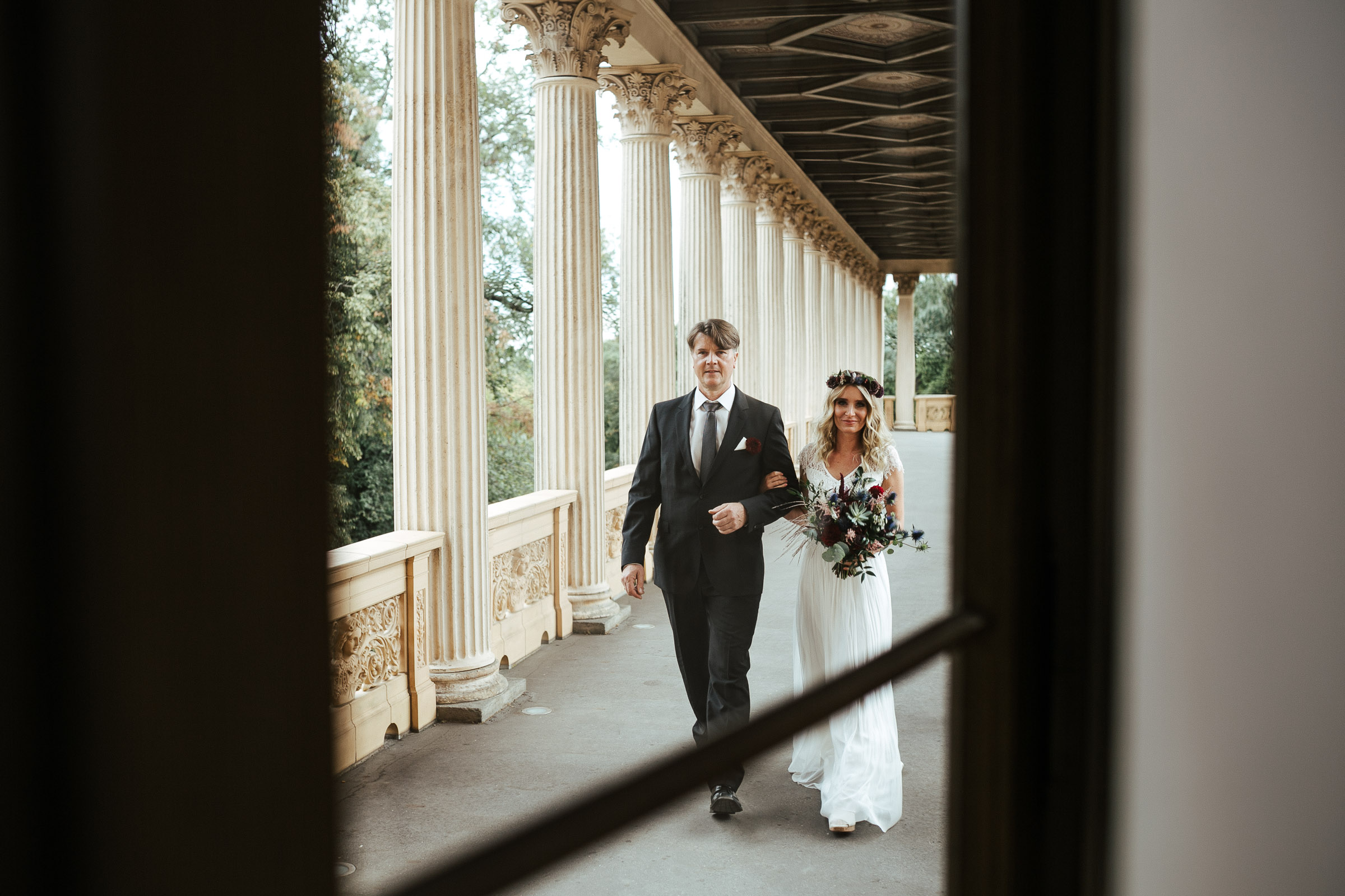 Septemberhochzeit: Braut läuft durch den Laubengang zur Trauung