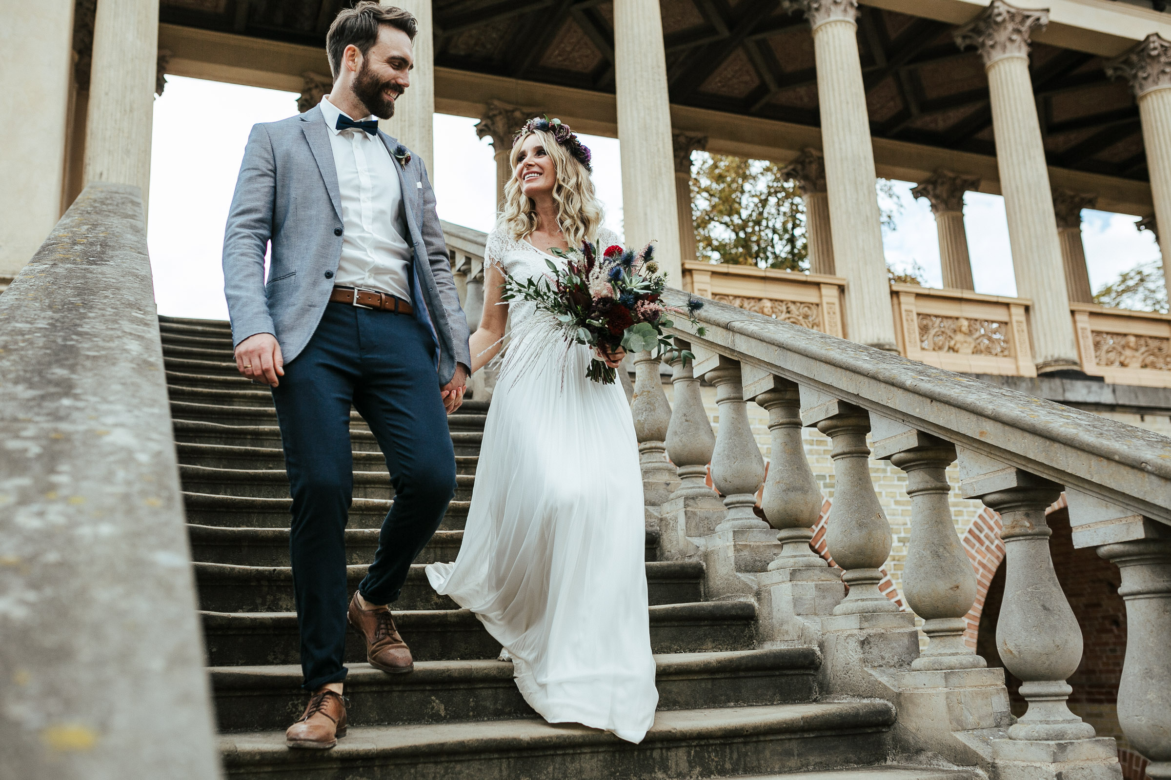 Septemberhochzeit: Brautpaar läuft gemeinsam die Schlosstreppe hinunter