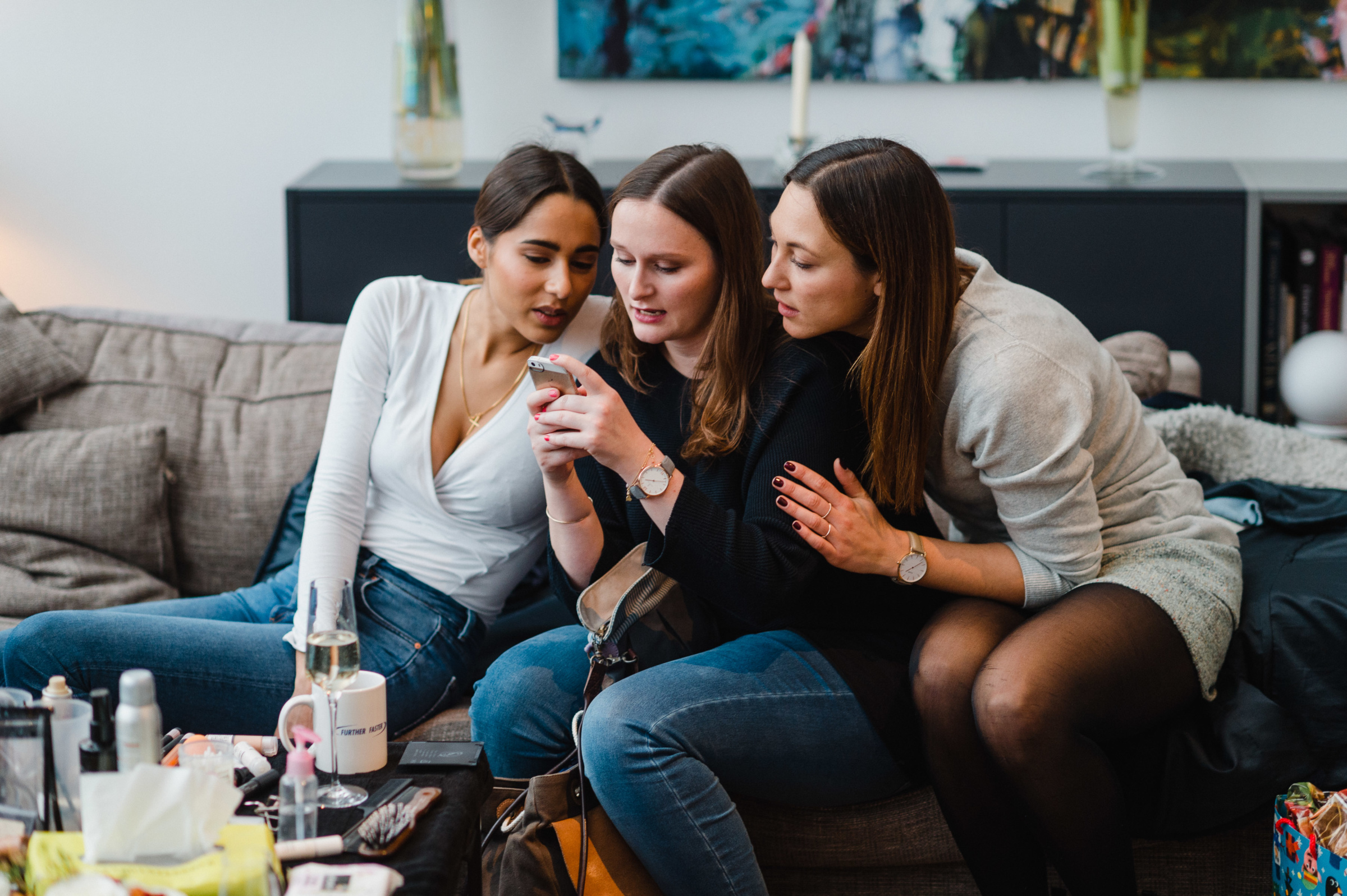 Winterhochzeit: Braut und Freundinnen schauen gemeinsam auf ein Handy