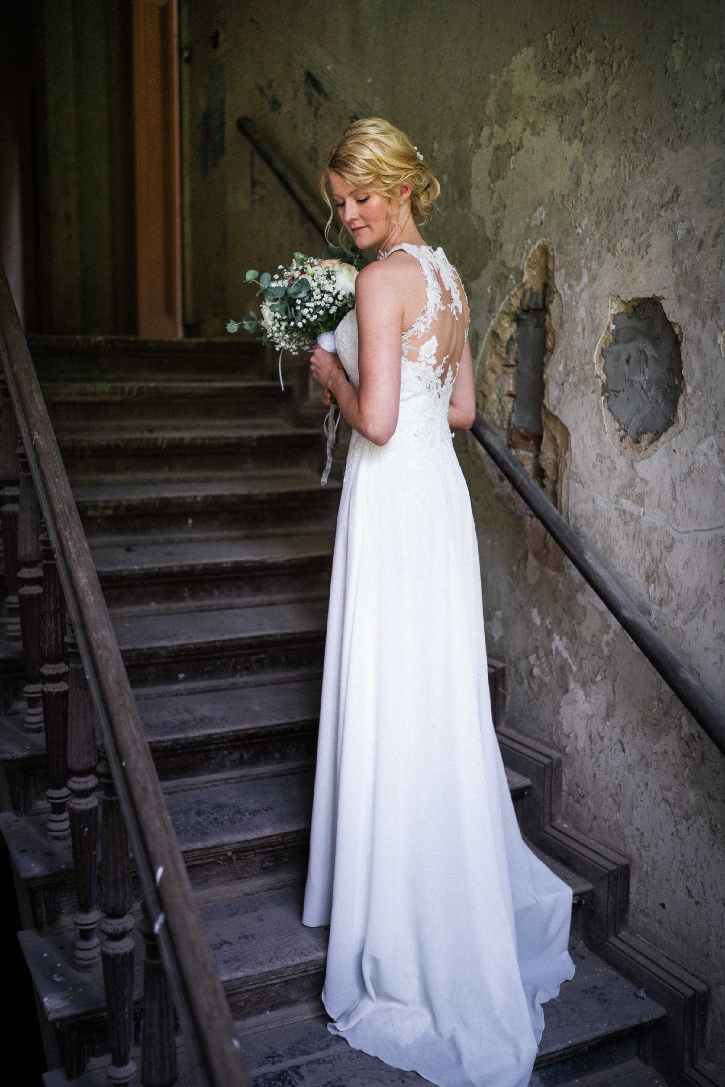 Hochzeit in Paderborn: Braut steht mit Brautstrauß auf einer Treppe