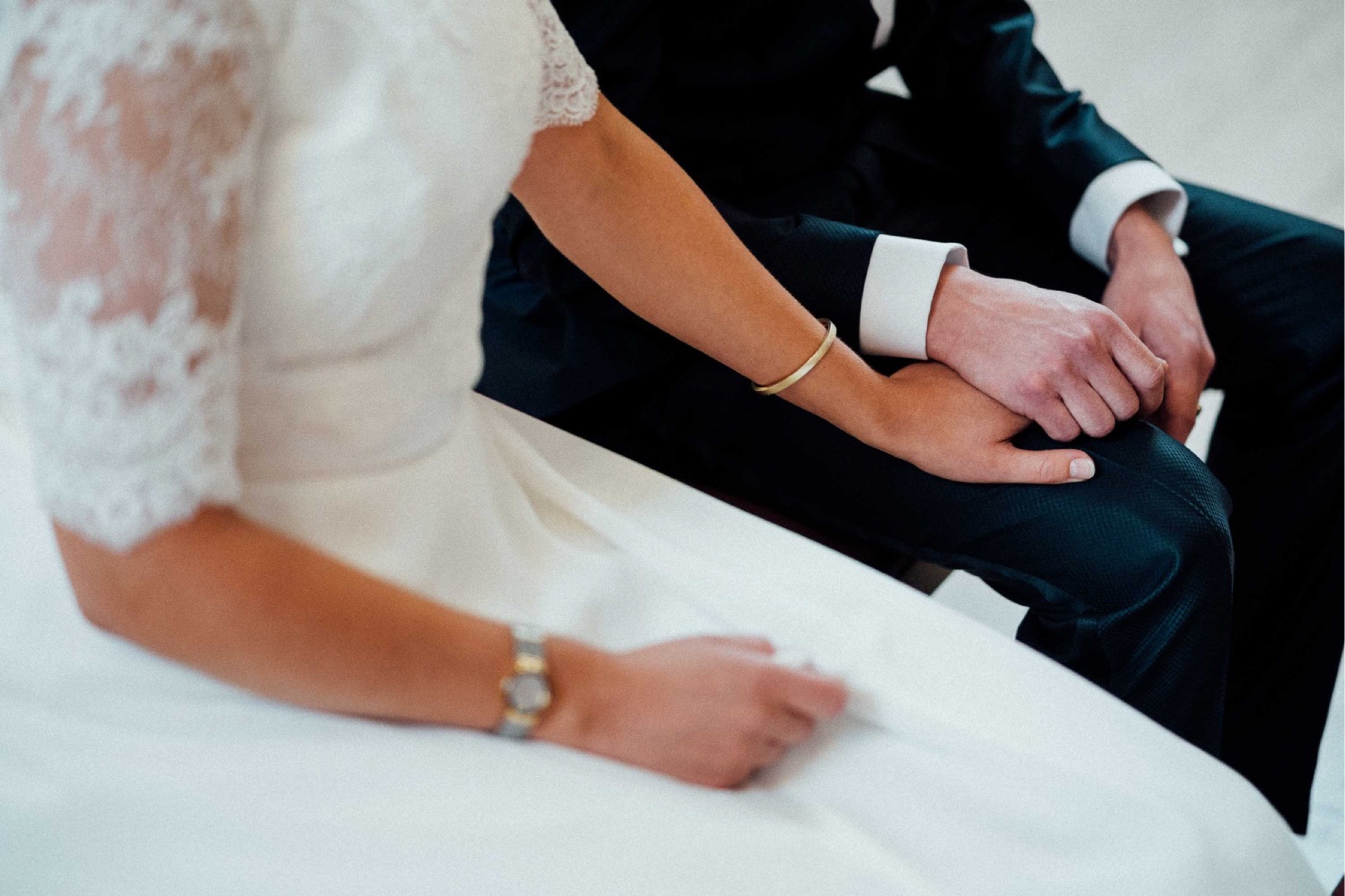 Herbsthochzeit: Brautpaar hält Händchen vor dem Altar
