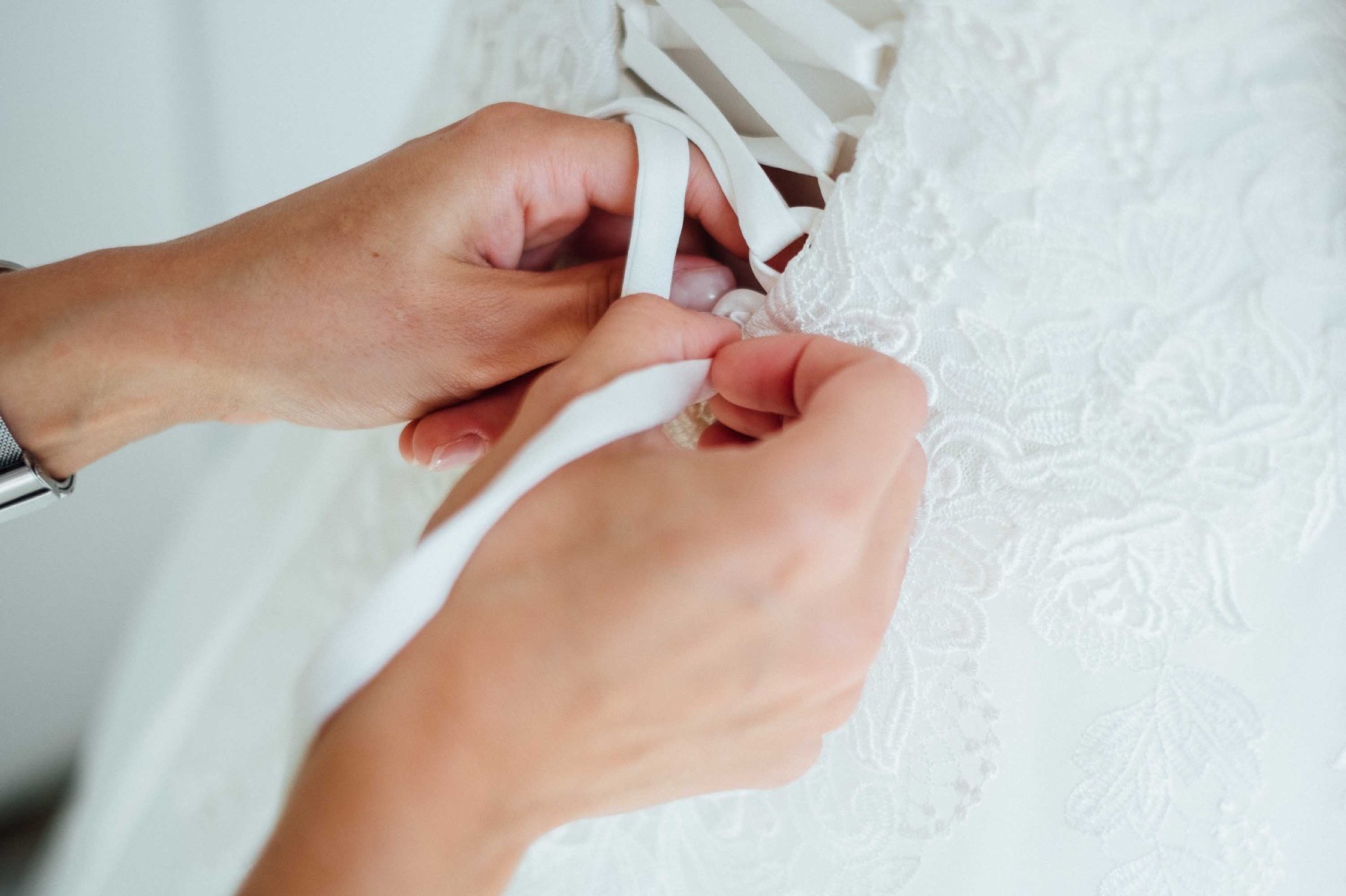 Hochzeit in Bremen: Trauzeugin knöpft der Braut das Kleid zu