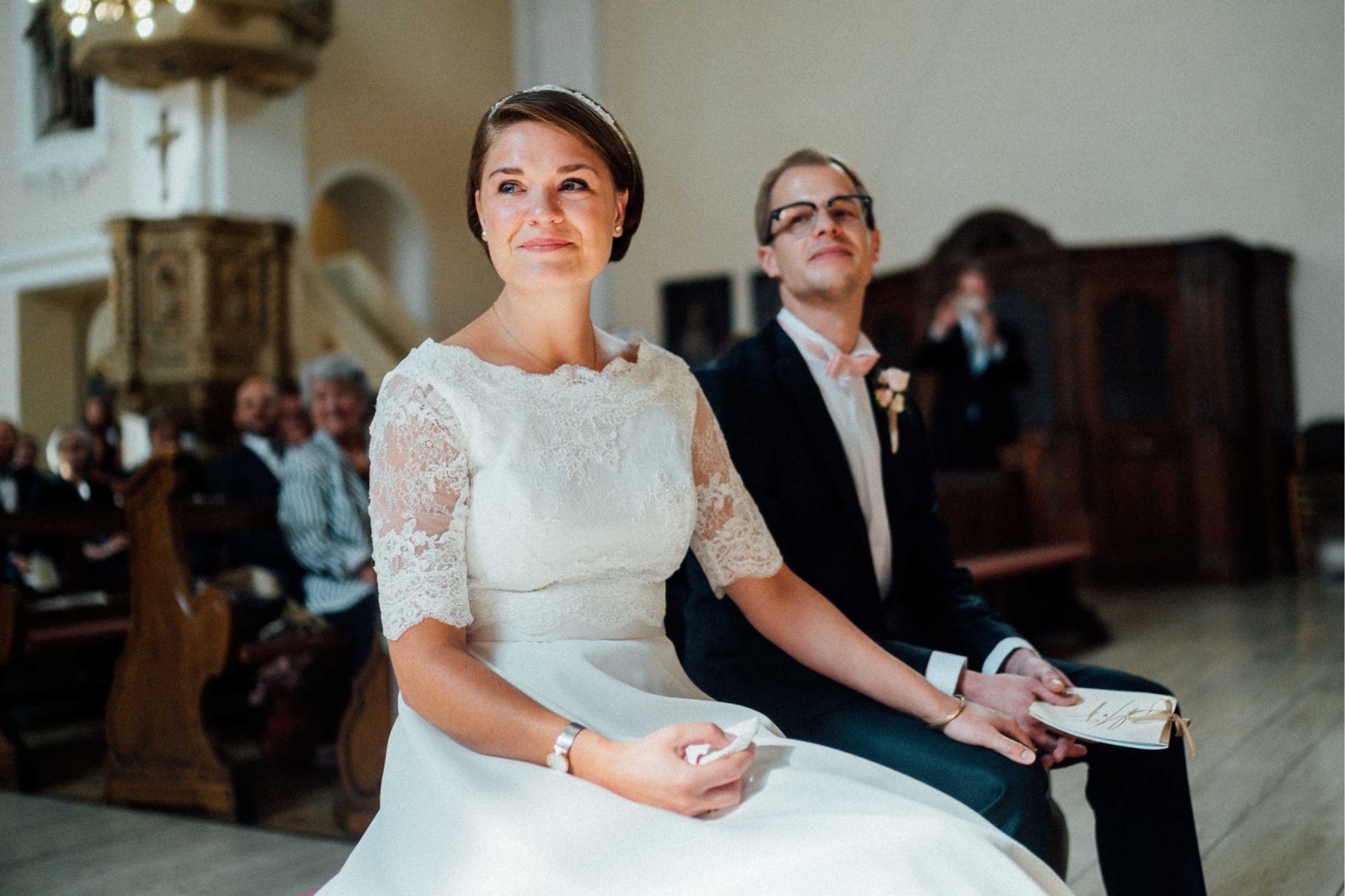 Herbsthochzeit: Braut mit Tränen in den Augen vor dem Altar