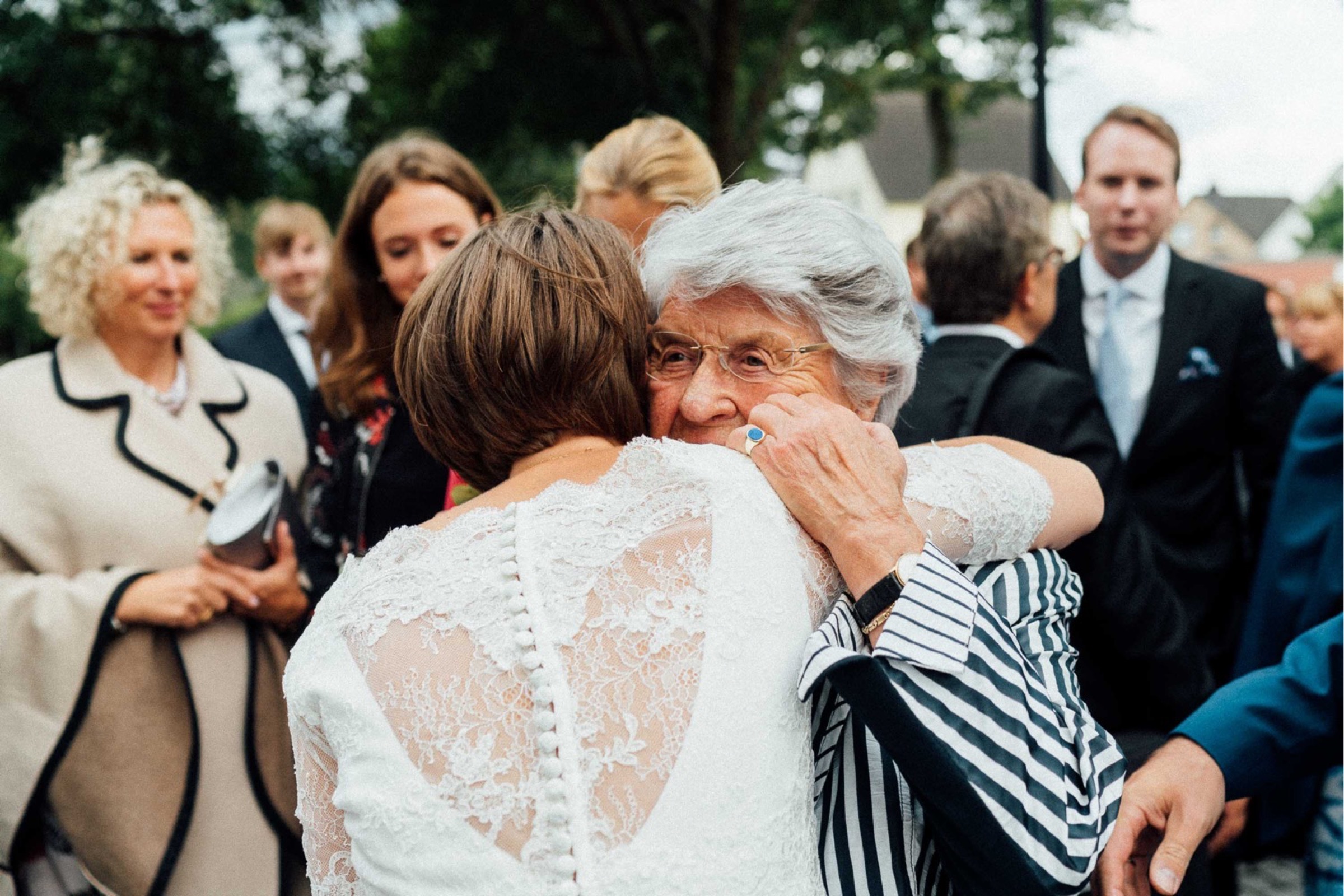 Herbsthochzeit: ein Hochzeitsgast umarmt die Braut