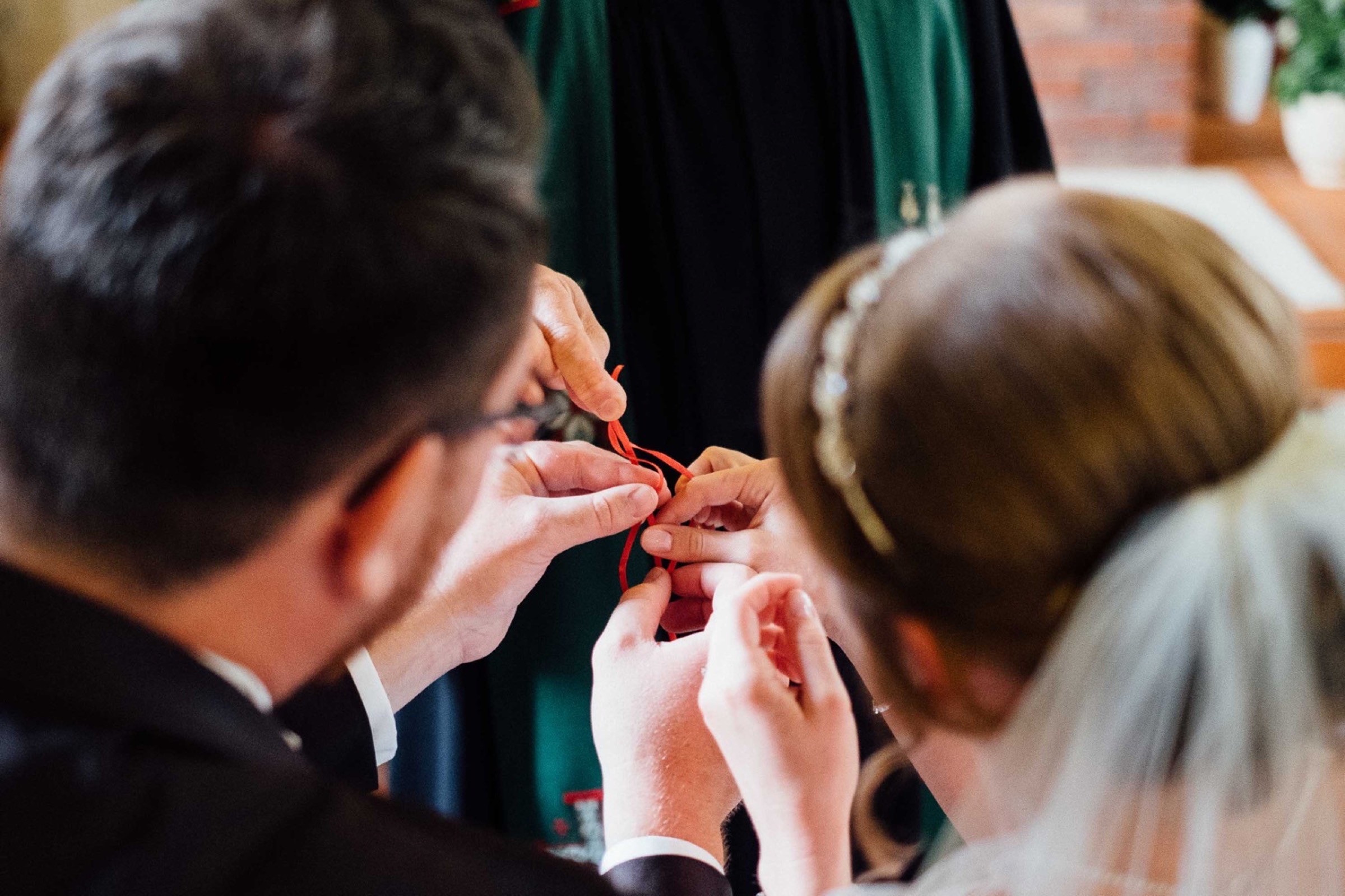 Hochzeit in Bremen: der Pfarrer hält rote Bänder, die das Brautpaar verknüpft